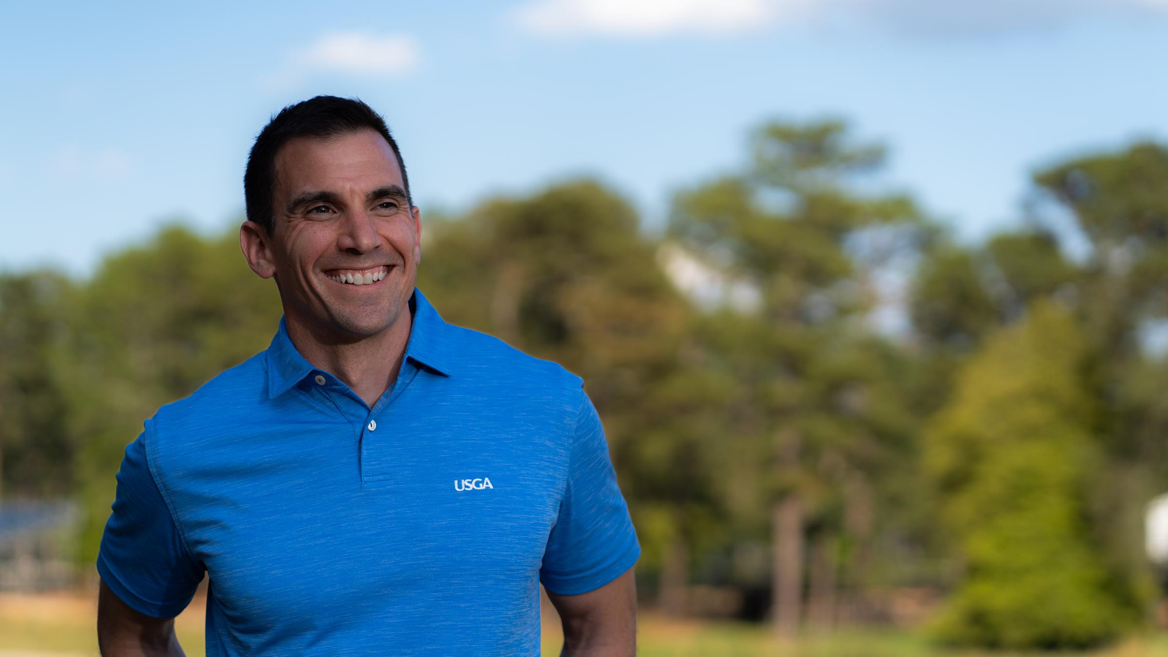 Anthony Santora M.S. ’05 headshot outside wearing a blue USGA shirt