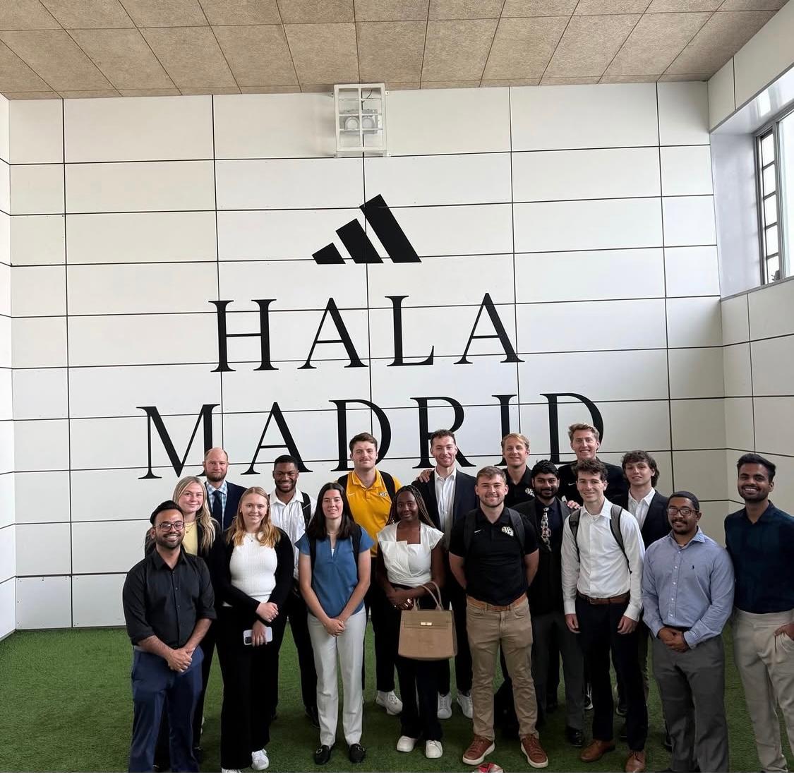 Bupe stands with a group of students in a Real Madrid training facility 