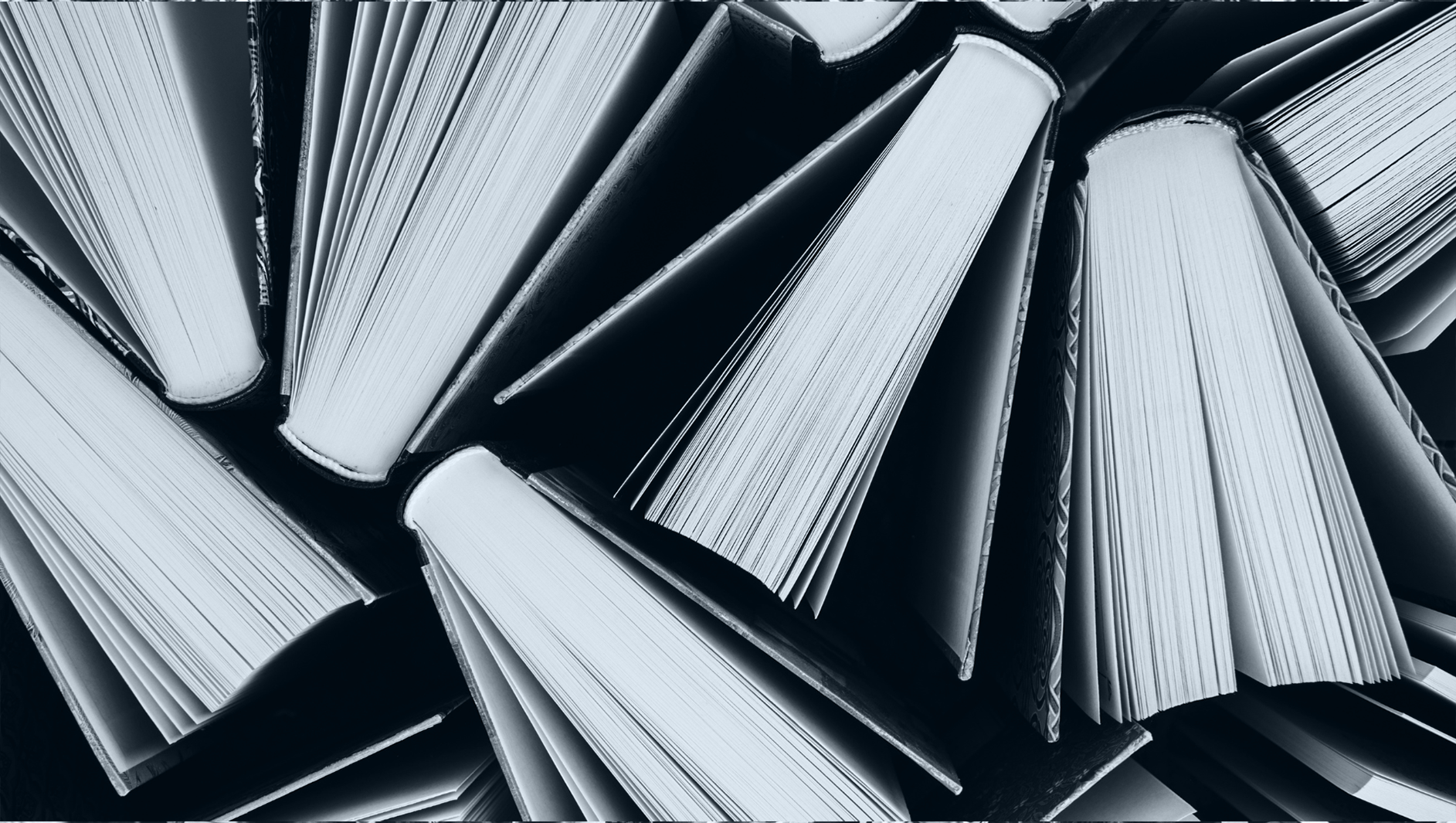Books from above. Black and white image with light blue overlay.