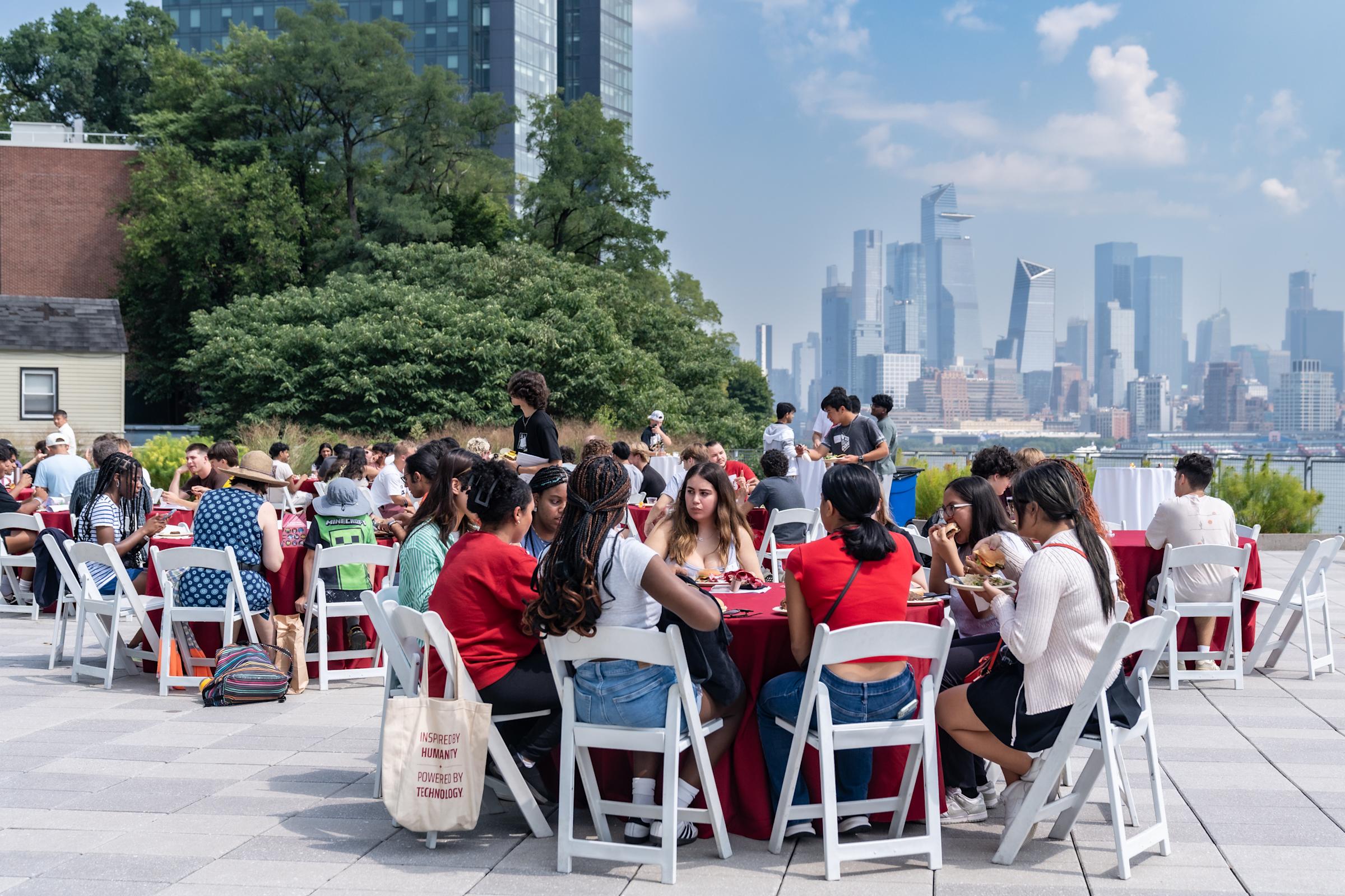 Students sit on the Babbio Center patio eating lunch.