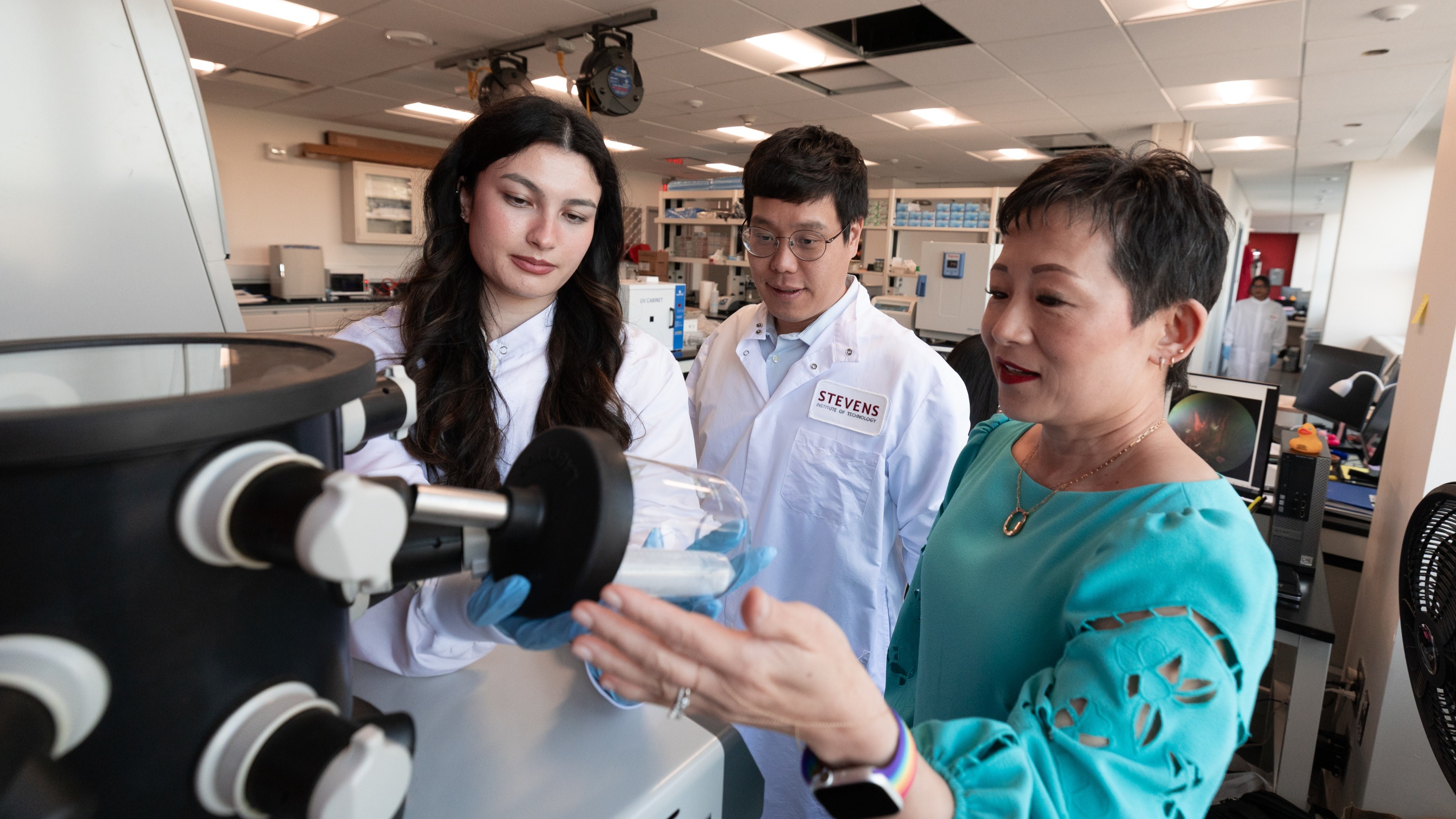 Two research students and professor Jennifer Kang-Mieler working in a lab.