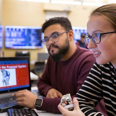 2 Computer Science students working on computers