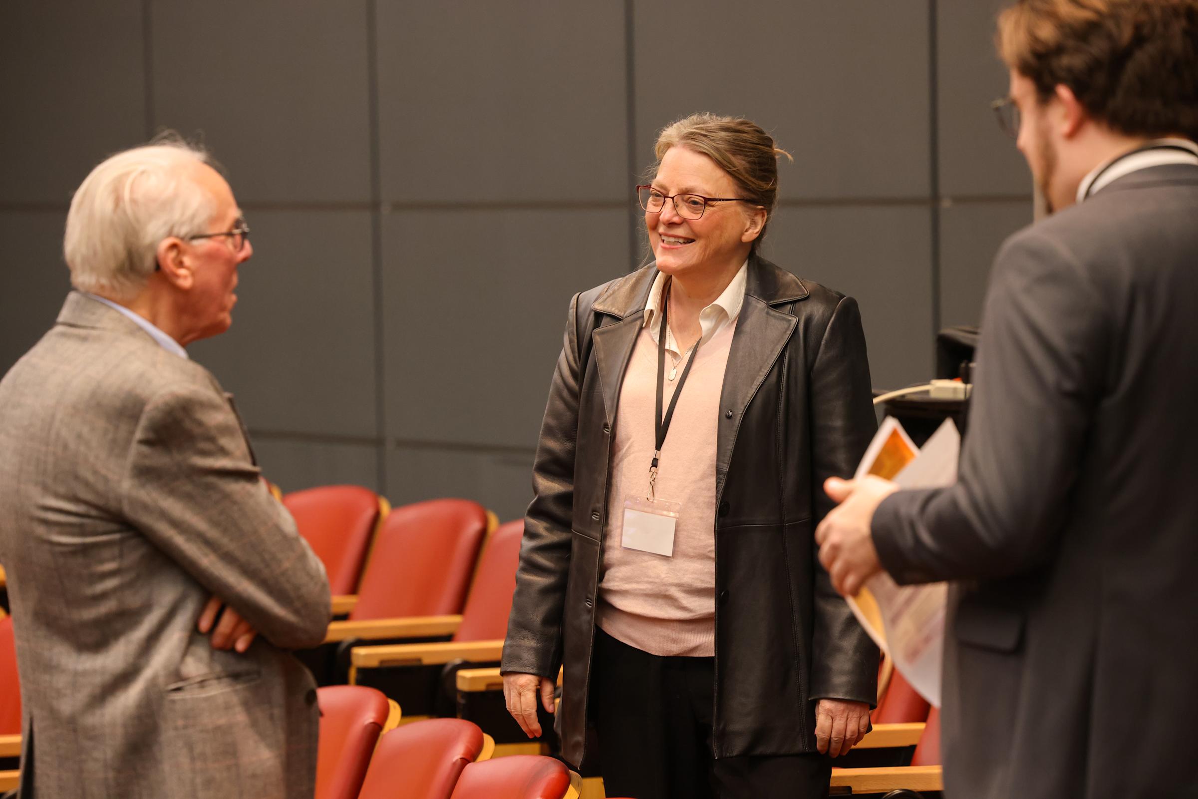A group of CRAFT participants speak in the auditorium, smiling. 