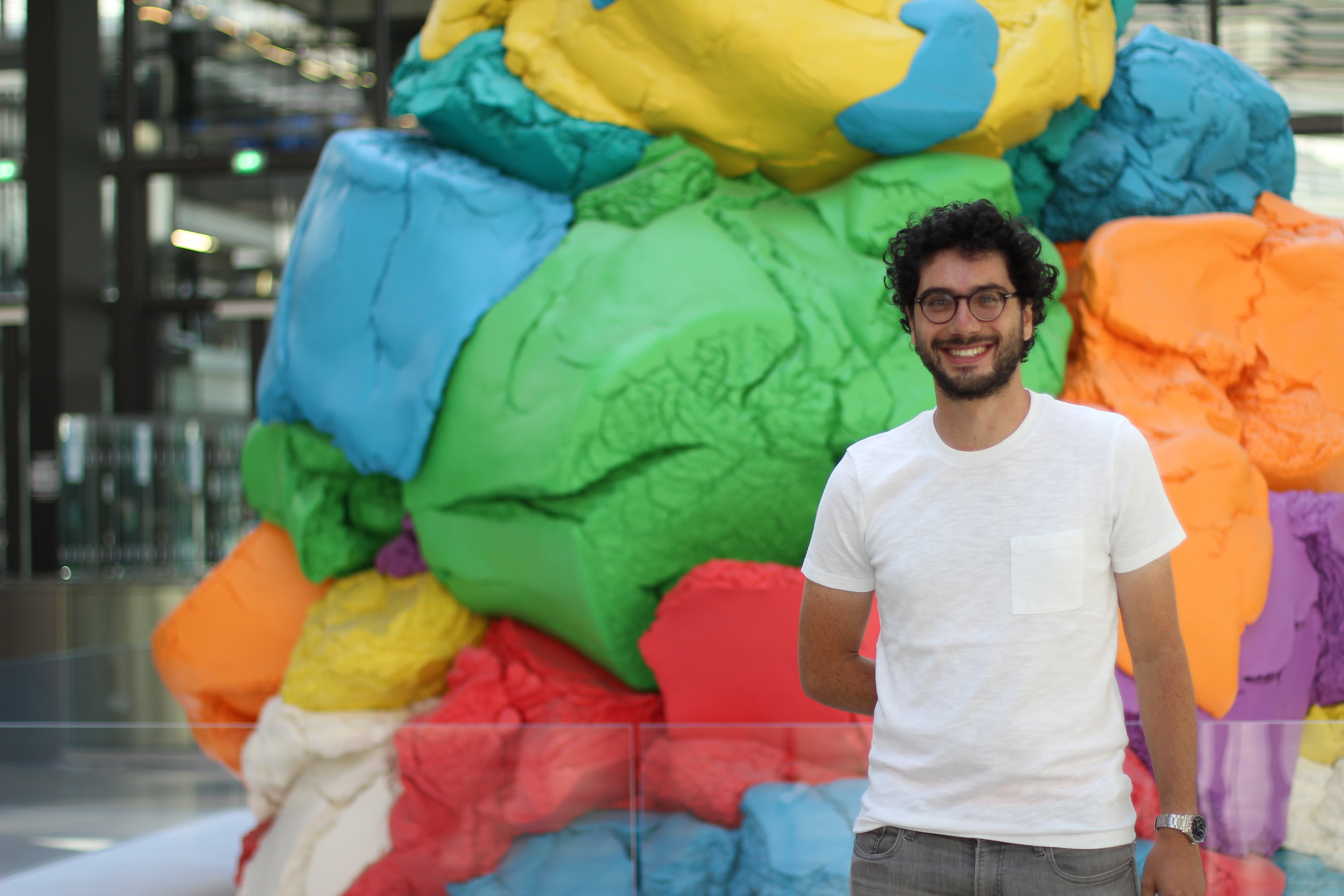 Photo of entrepreneur and data scientist Raphael Presberg M.S. '18 in front of a colorful sculpture