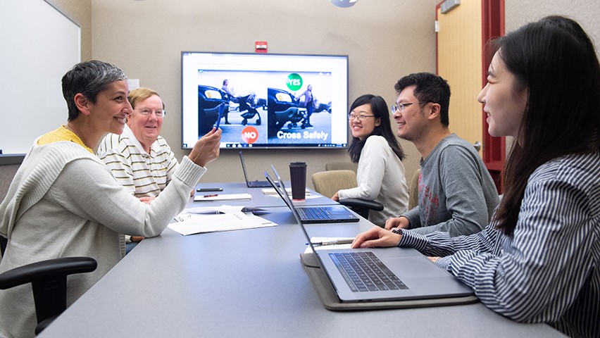 Five professionals working around a conference table.