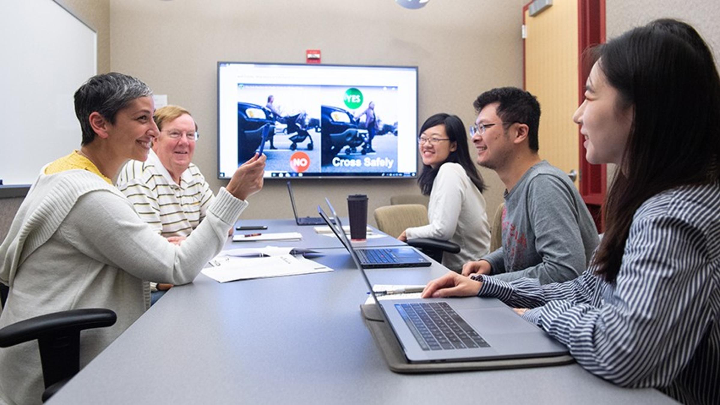 Five professionals working around a conference table.