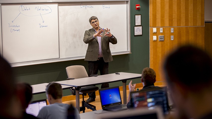 Hamed Ghoddusi calls on a student in class as he stands before a white board in a lecture hall.
