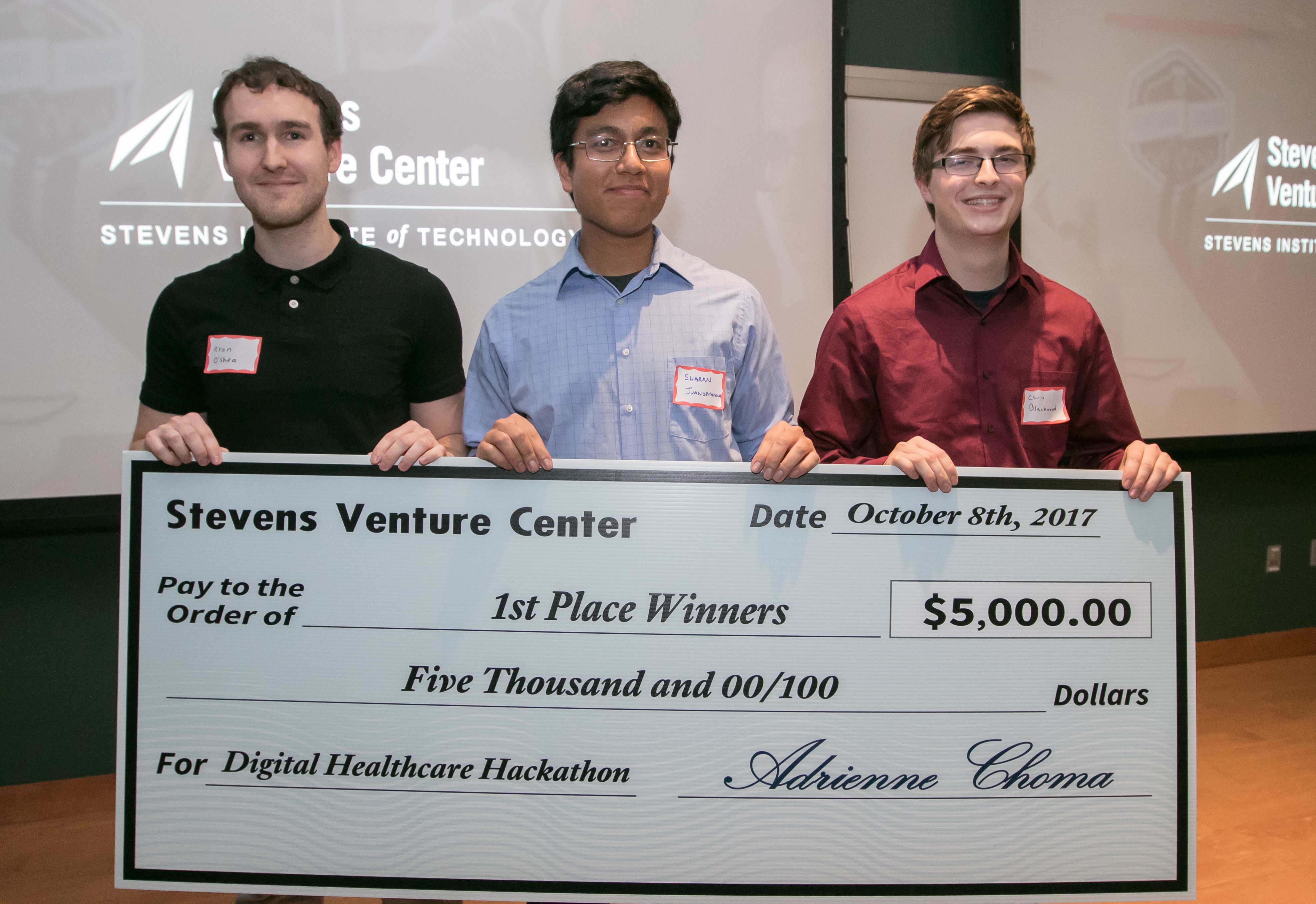 Hackathon winners Team Ethyl display ceremonial check. From left: Ryan O'Shea, Sharan Juangphanich and Chris Blackwood.