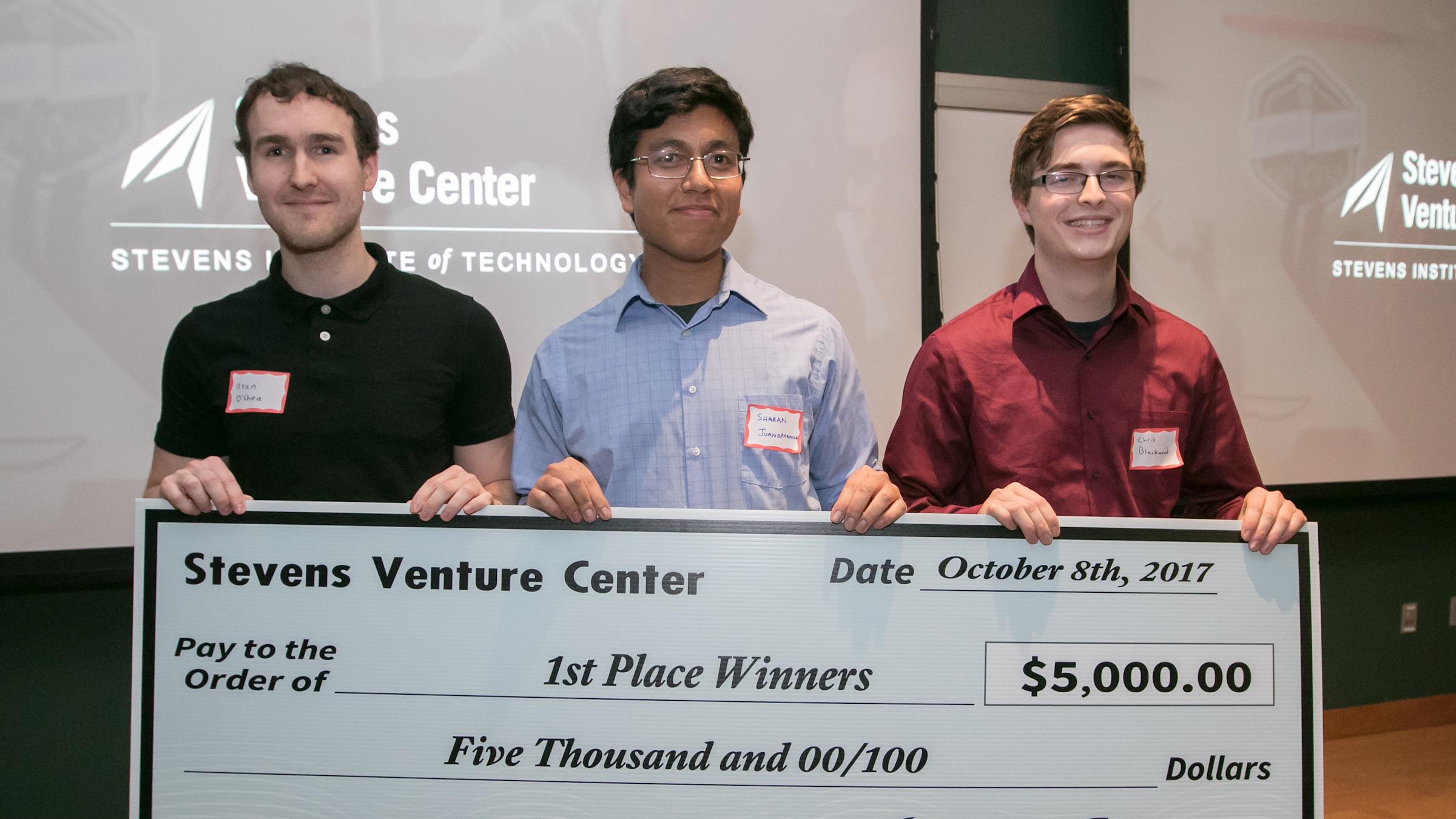 Hackathon winners Team Ethyl display ceremonial check. From left: Ryan O'Shea, Sharan Juangphanich and Chris Blackwood.