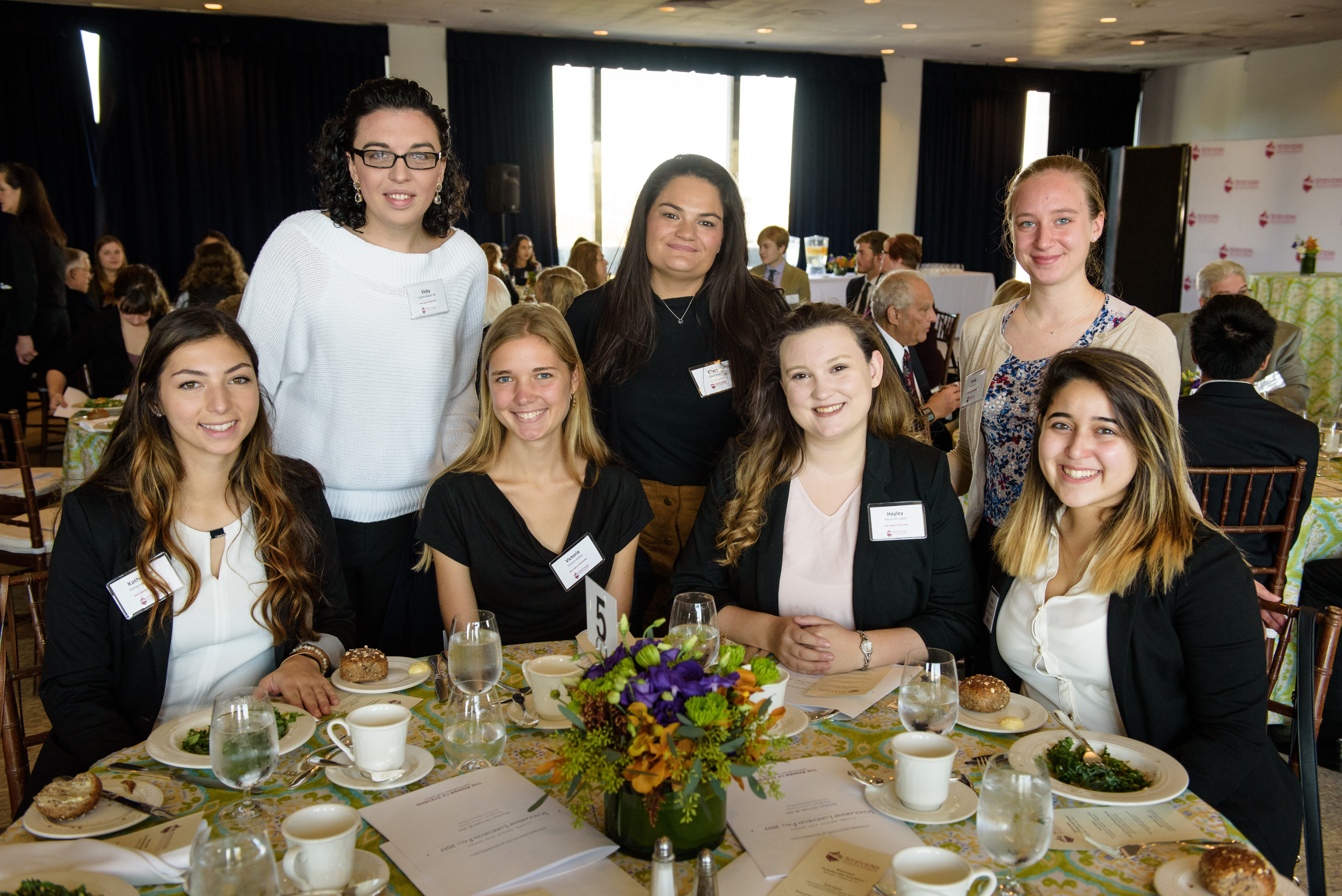 Five Stevens students gathered at a table in Bissinger Hall where luncheon was held