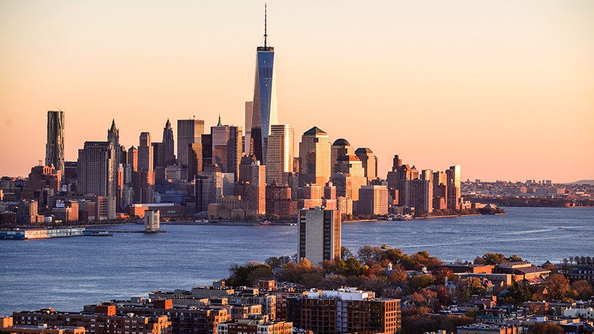 The Stevens campus and downtown New York City skyline at sunset.
