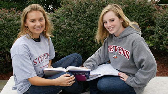 Two women studying outdoors on the Stevens campus.