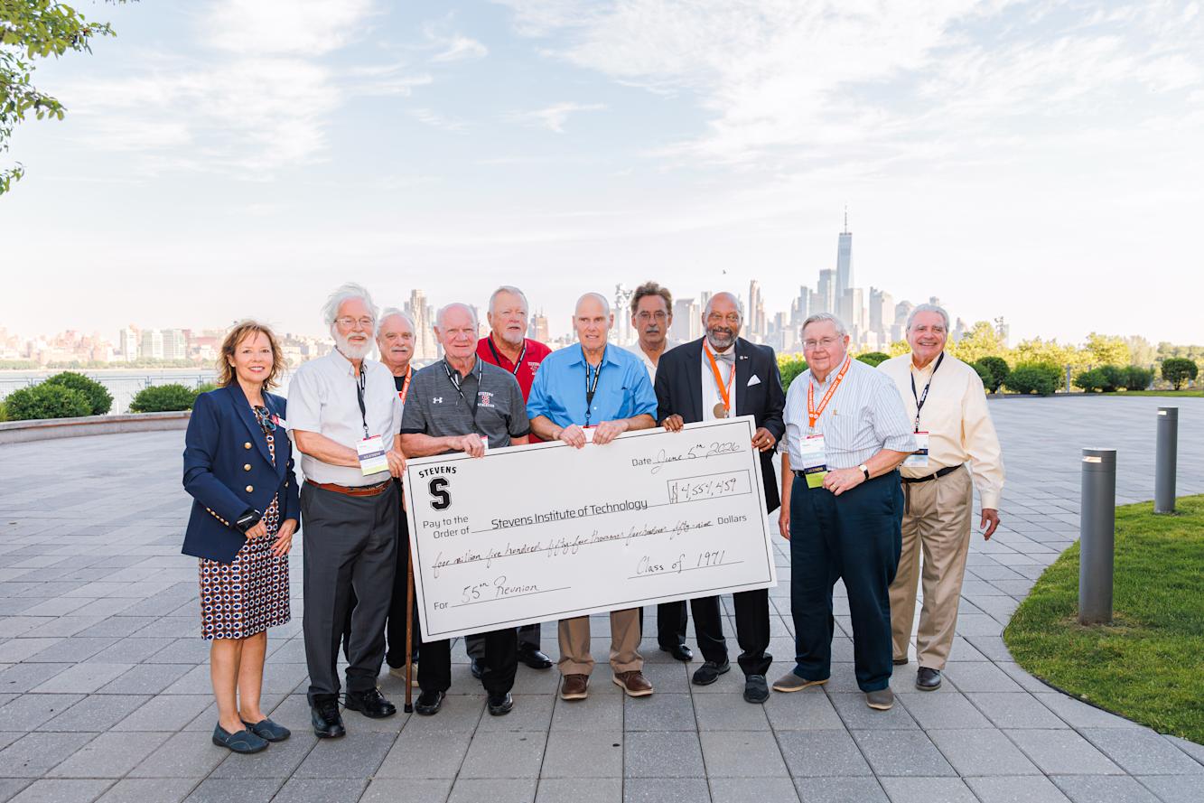 Members of the Class of 1971 pose outdoors with novelty check representing 55th reunion class gift
