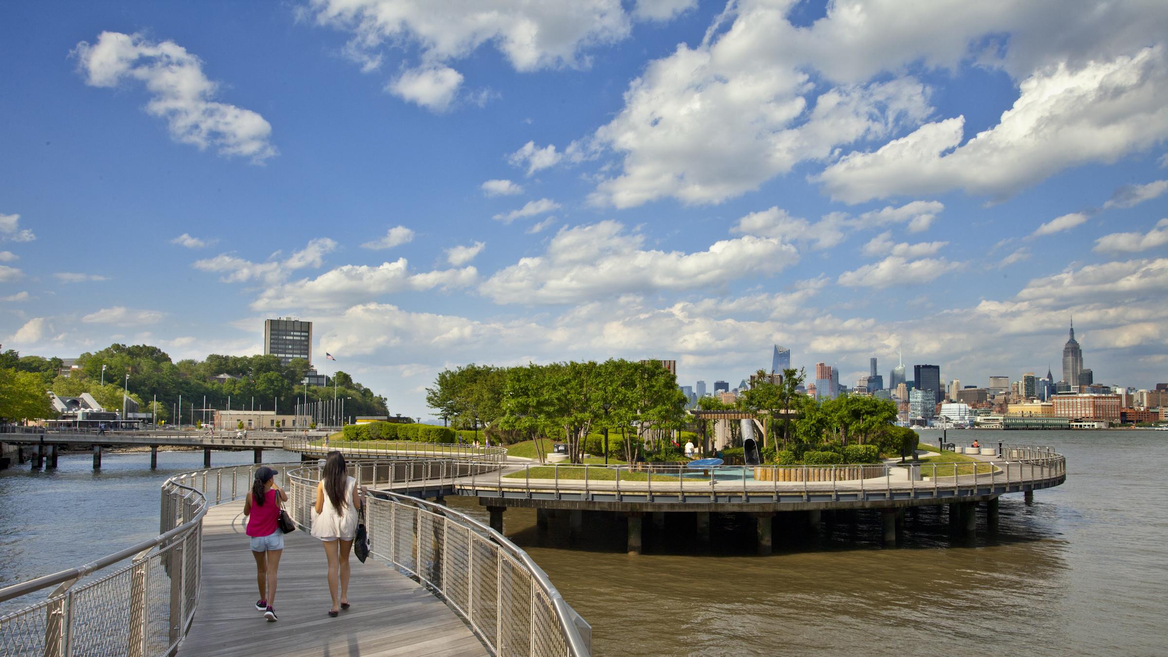2 female students walking on bridge over water