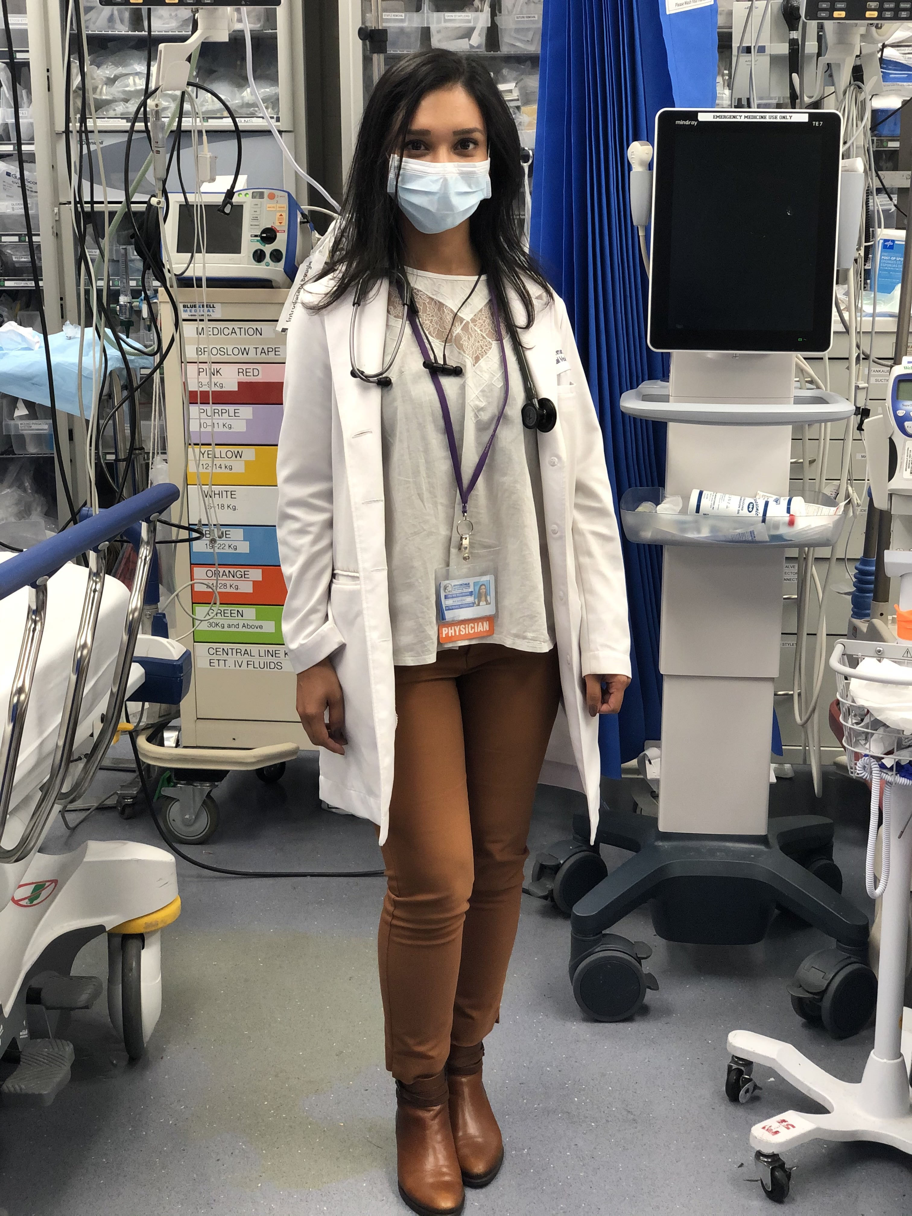 Portrait of resident physician Irene Rahman-Garcia ’12 wearing a mask in a hospital room