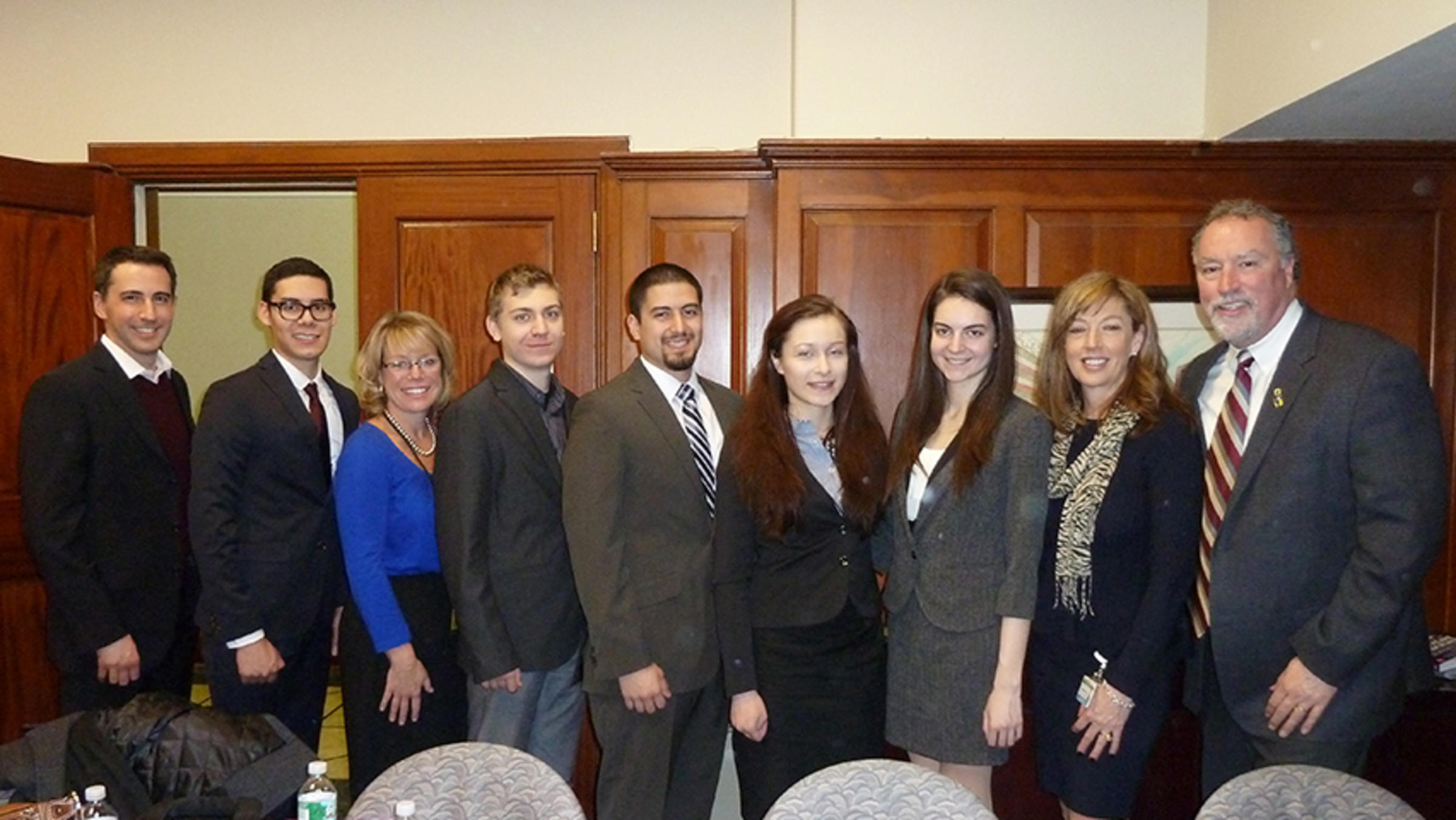 A group of students, faculty and hospital employees in the Monmouth Medical Center boardroom.