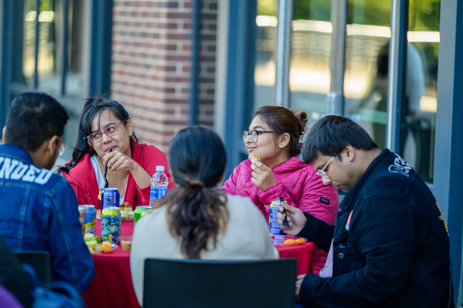 Five people talking and eating at an outdoor table at Stevens.