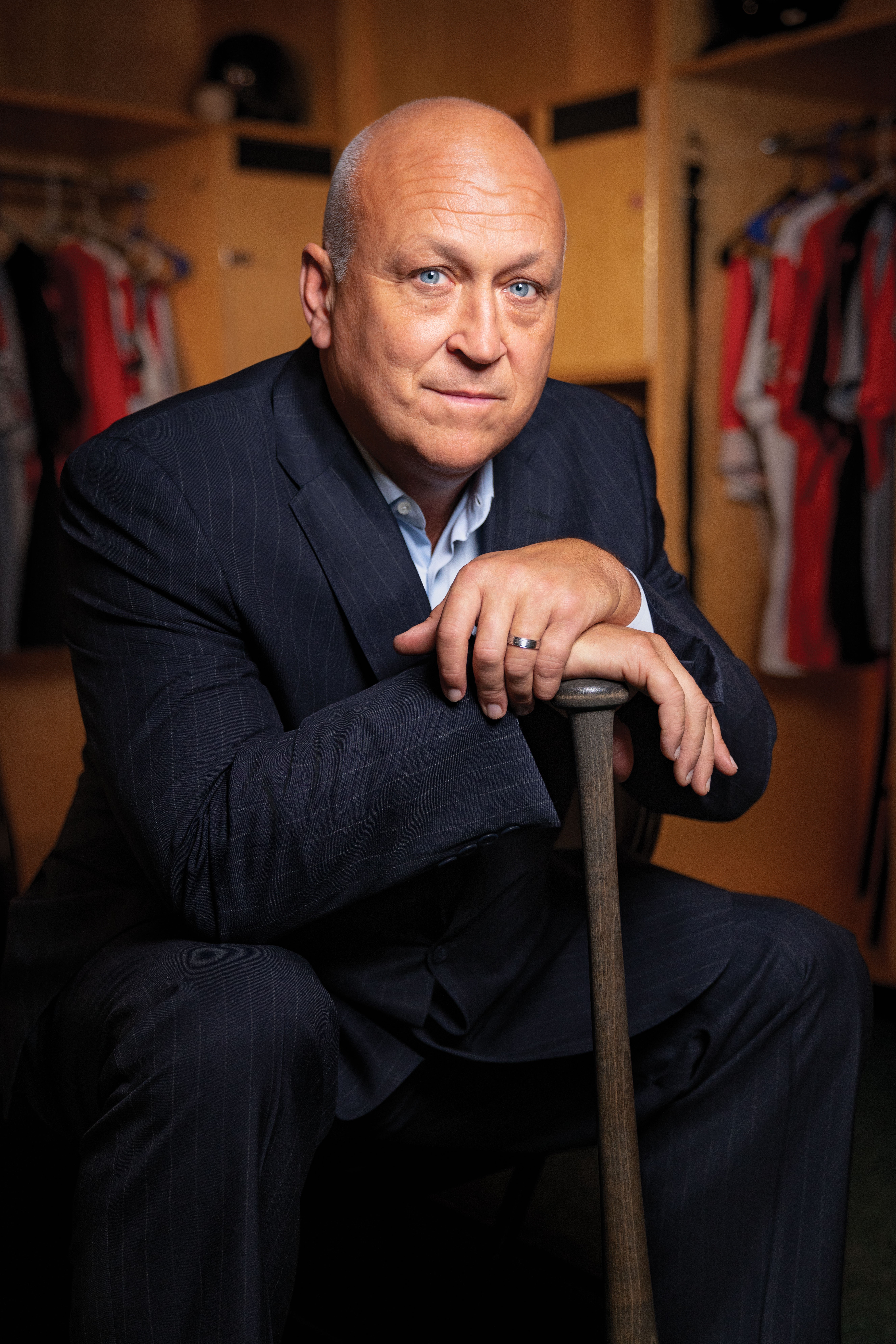 Cal Ripken, Jr. sitting in a locker room, holding a baseball bat