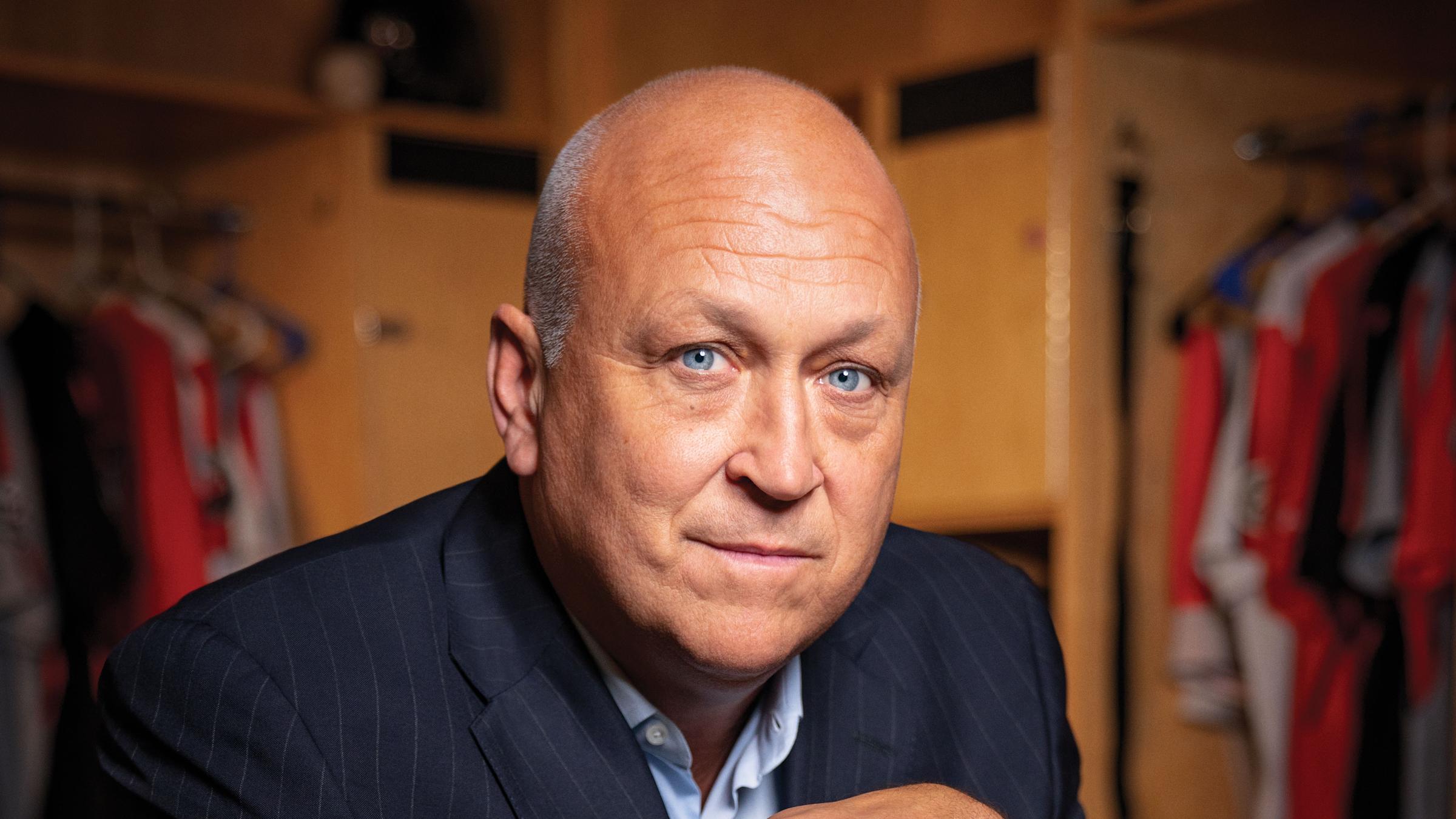 Cal Ripken, Jr. sitting in a locker room, holding a baseball bat