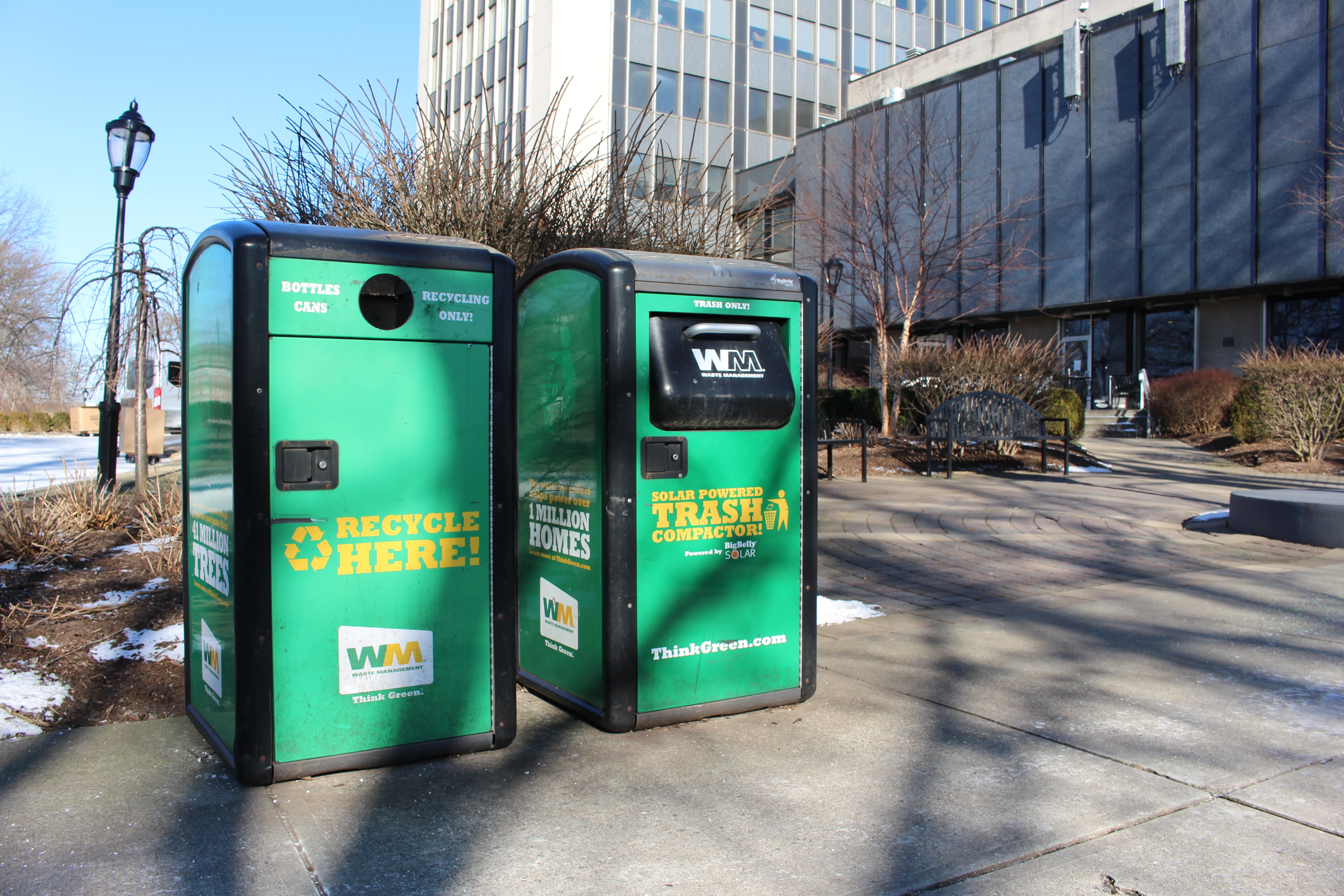 Two green solar trash compactors outside the Wesley J. Howe Center on the campus of Stevens Institute of Technology