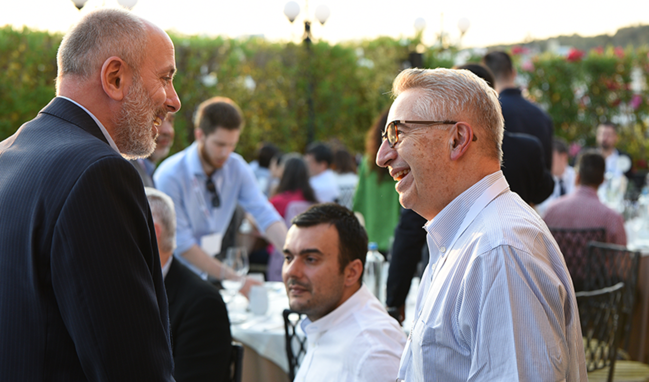 School of Business Dean Gregory Prastacos smiles while speaking with conference guest