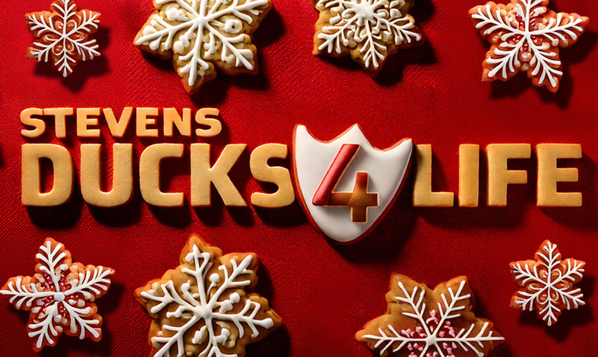 Holiday-themed graphic featuring the text “Stevens Ducks 4 Life” surrounded by decorated snowflake-shaped cookies on a red background.