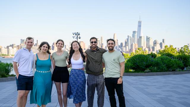 Group of young alumni pose for a picture on the Babbio patio during Alumni Weekend in 2024