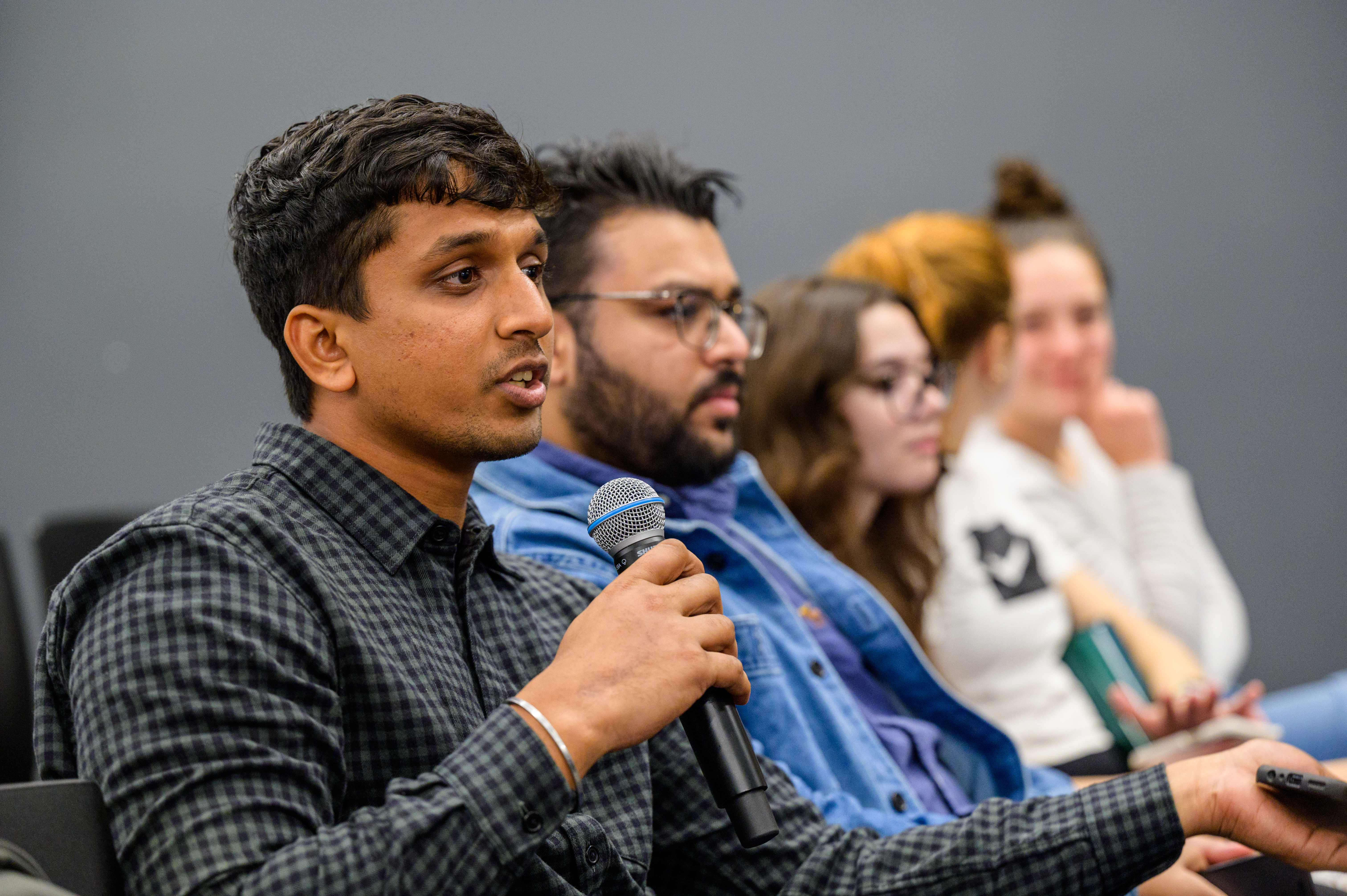 Alum speaks into microphone at Adulting 101 event