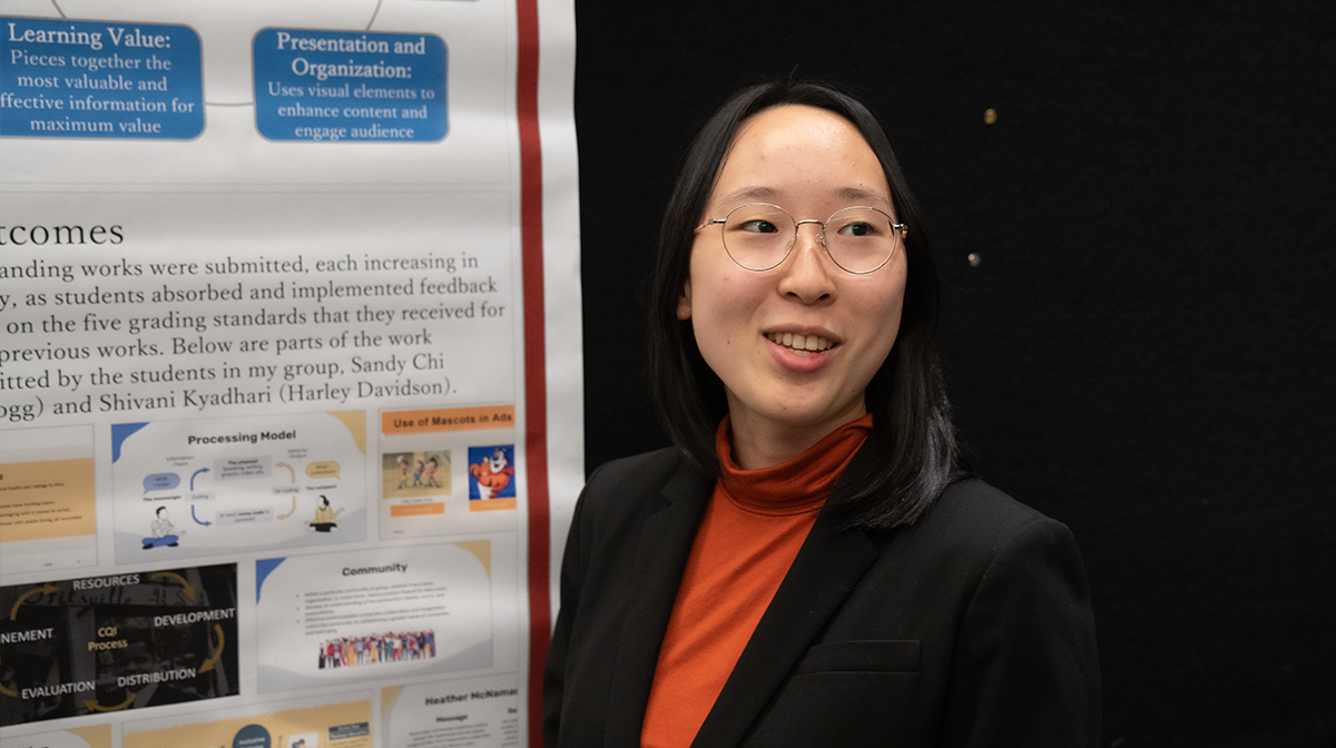 Riho Fukura stands in front of her poster describing her work with the S4 program.