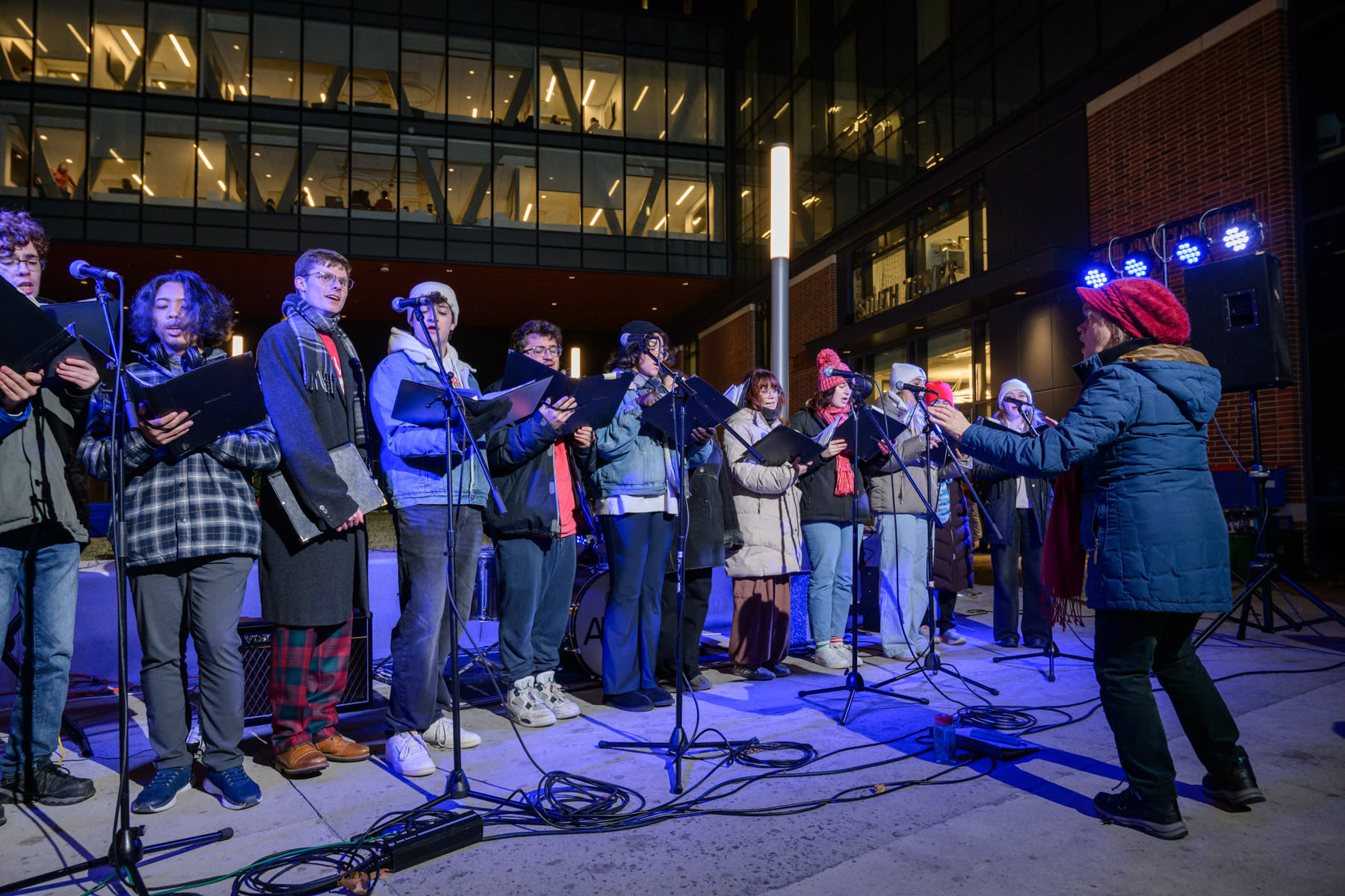 Group of students standing in a line in winter attire singing and holding sheet music