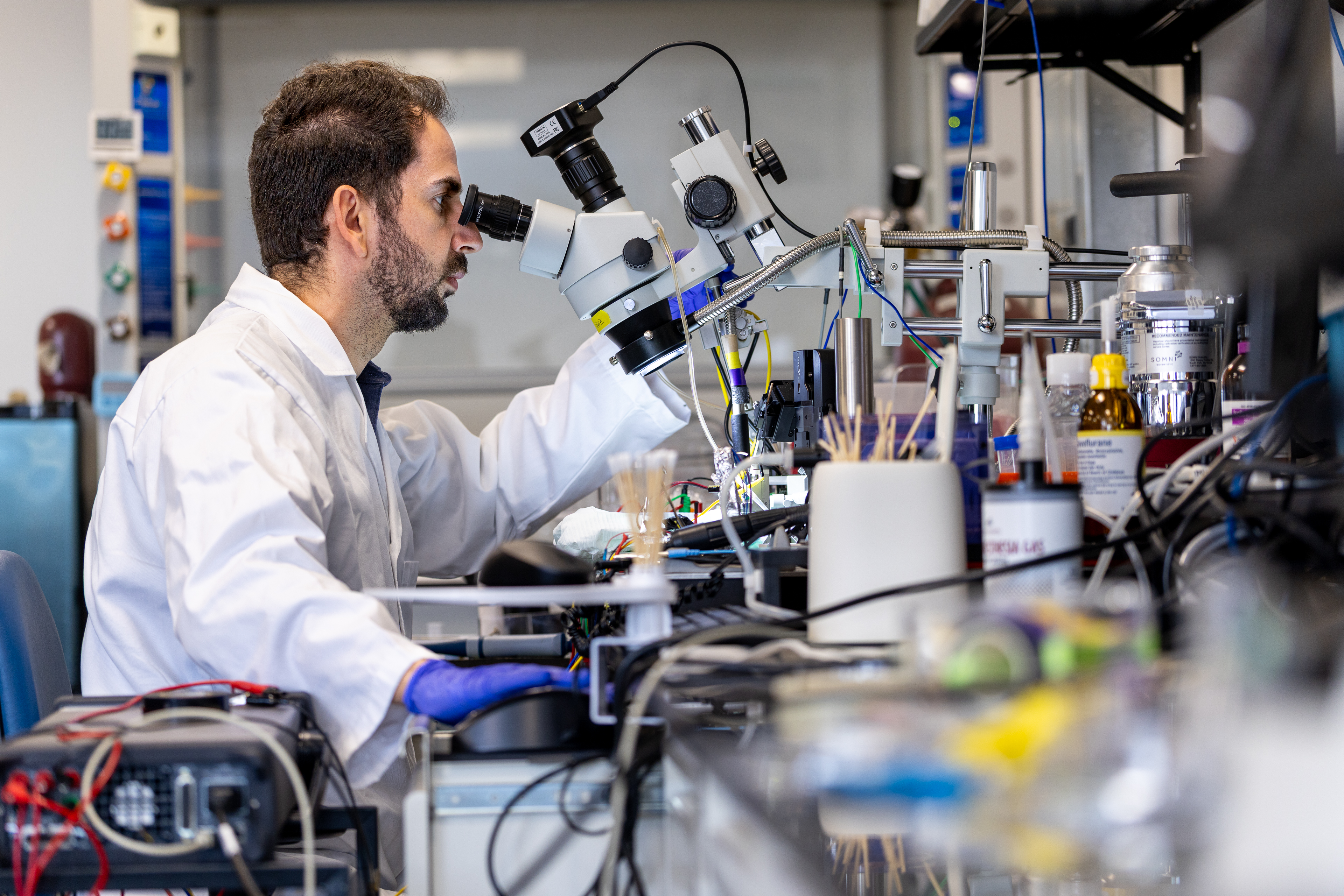 Professor Ilke Uguz working with a microscopic device in a lab.