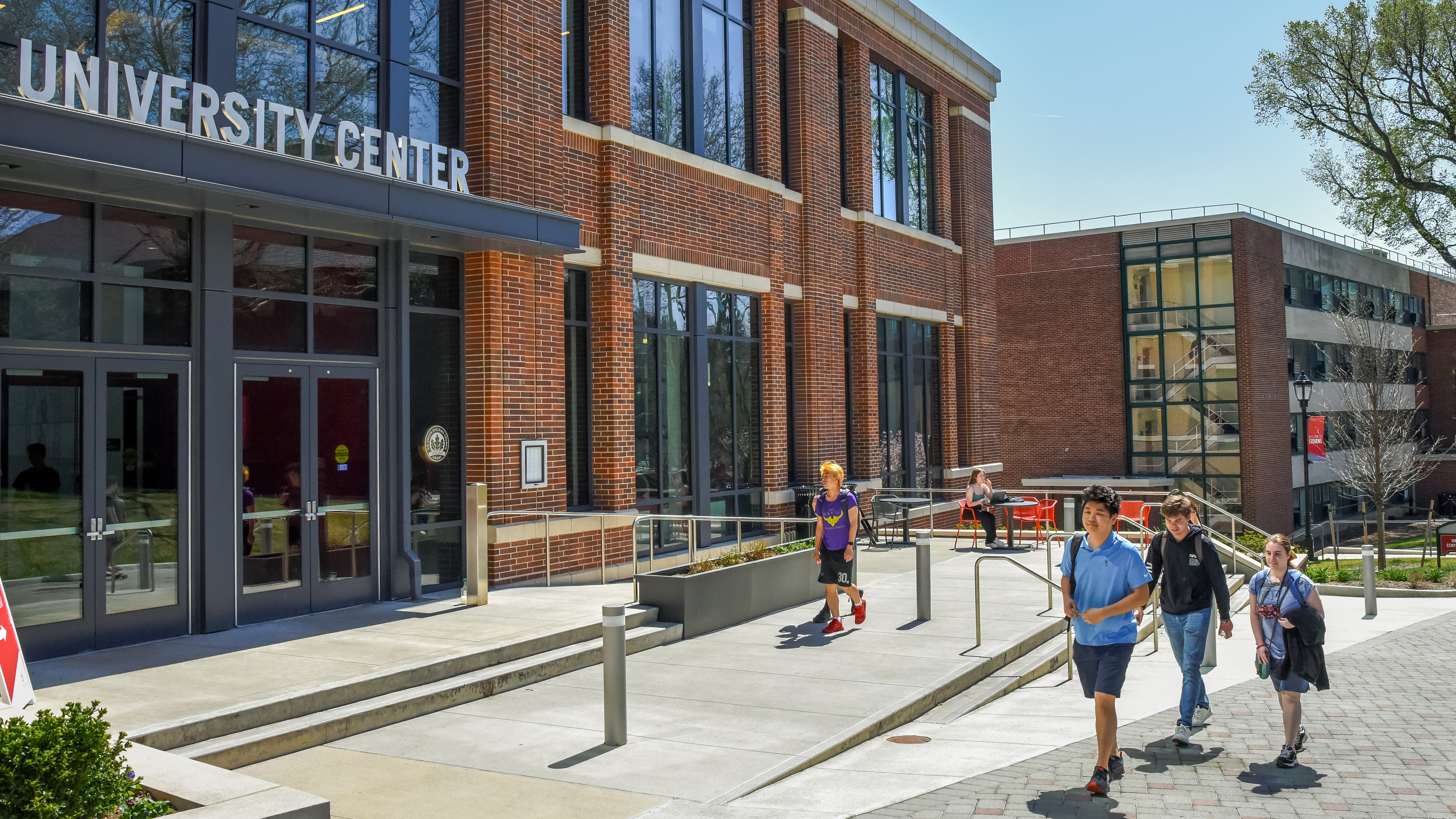 Students walking on campus on a sunny day.