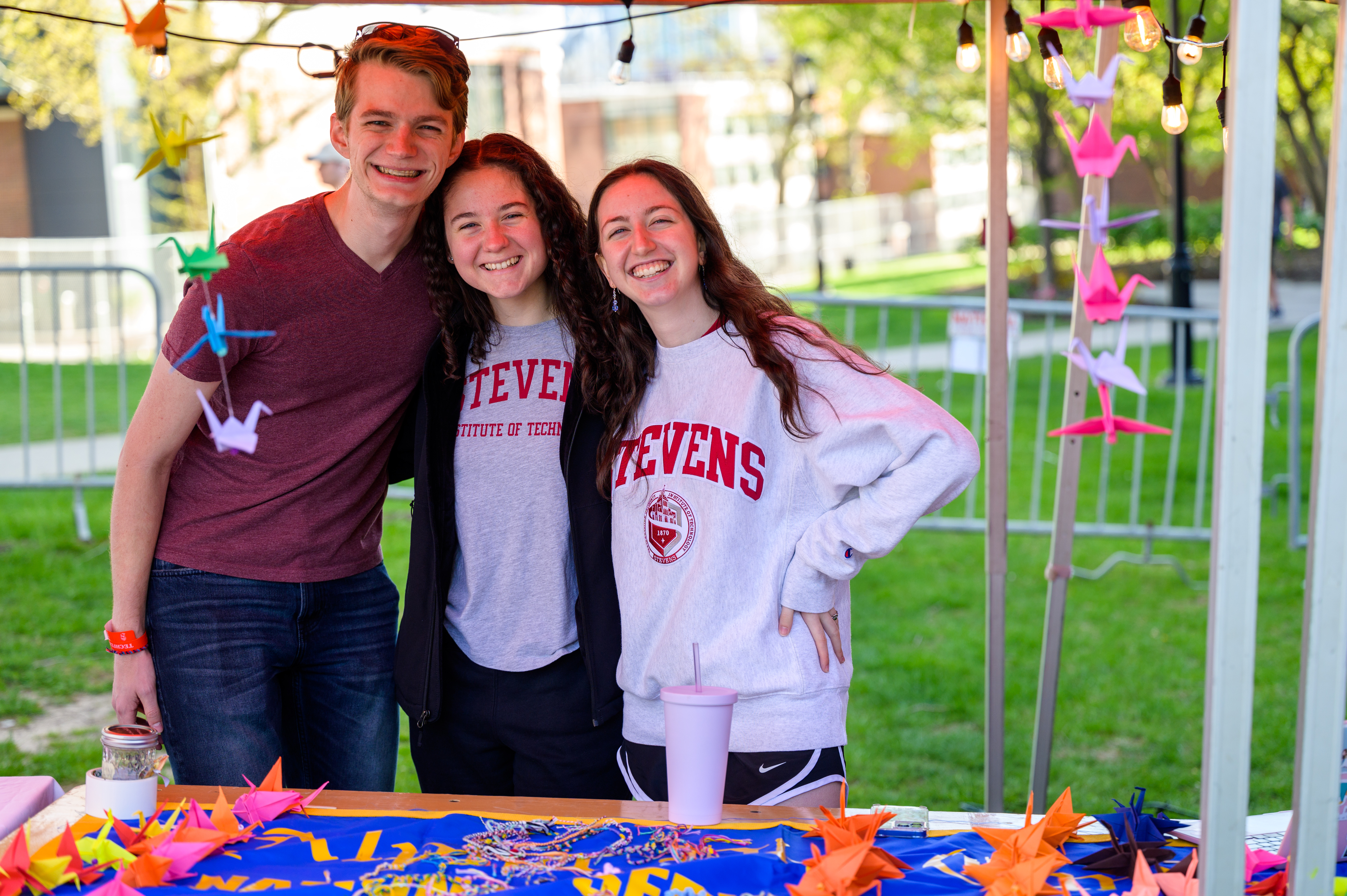 Three students smile in Stevens gear