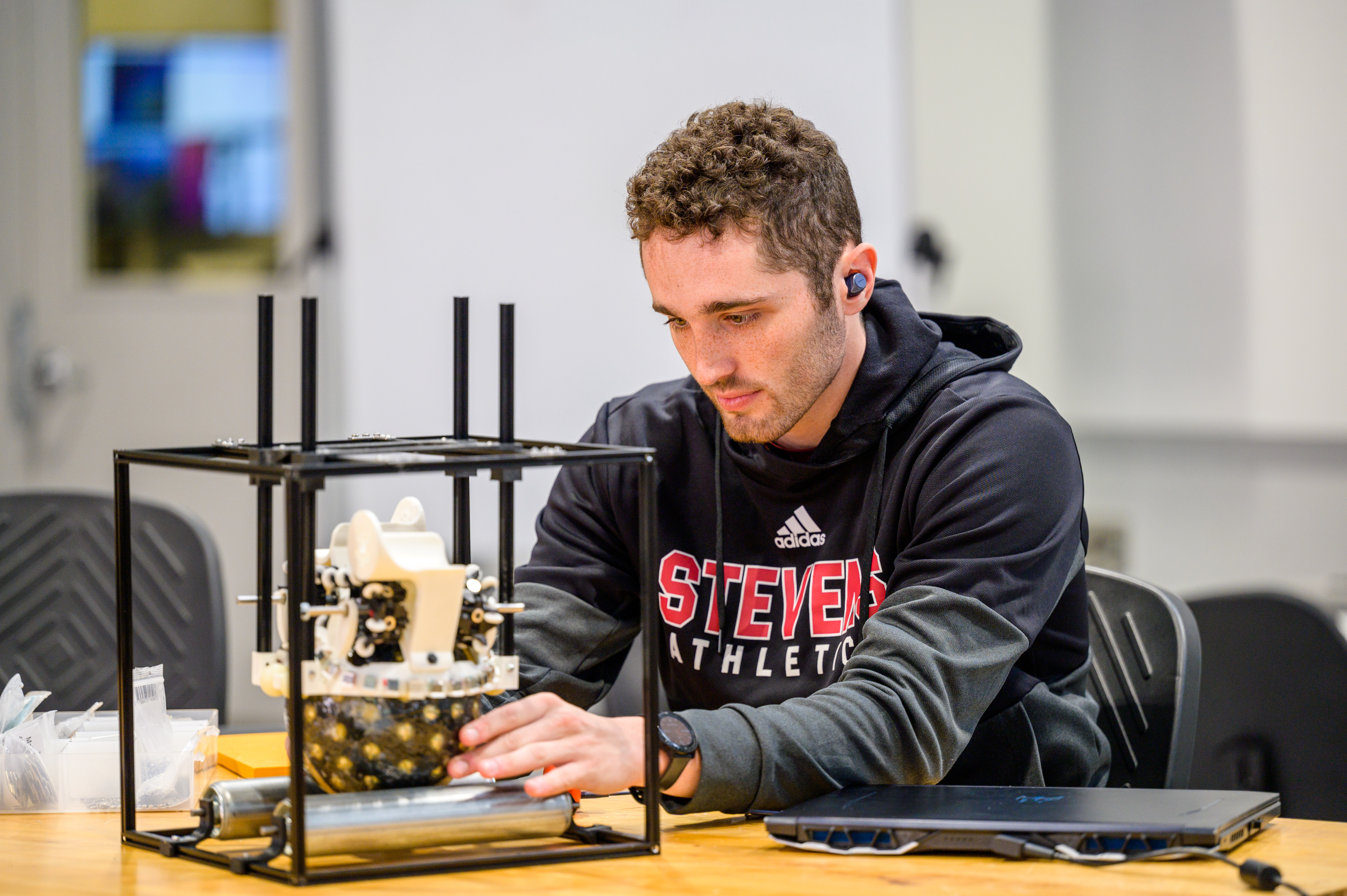 student wearing a black hoodie building his project