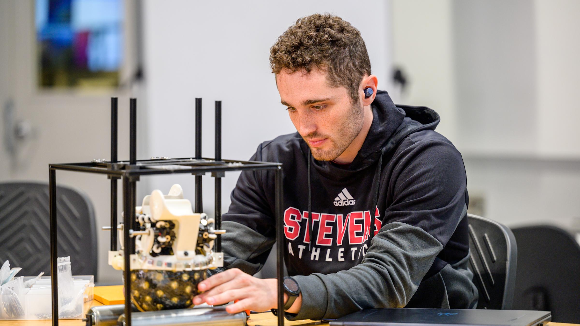 student wearing a black hoodie building his project