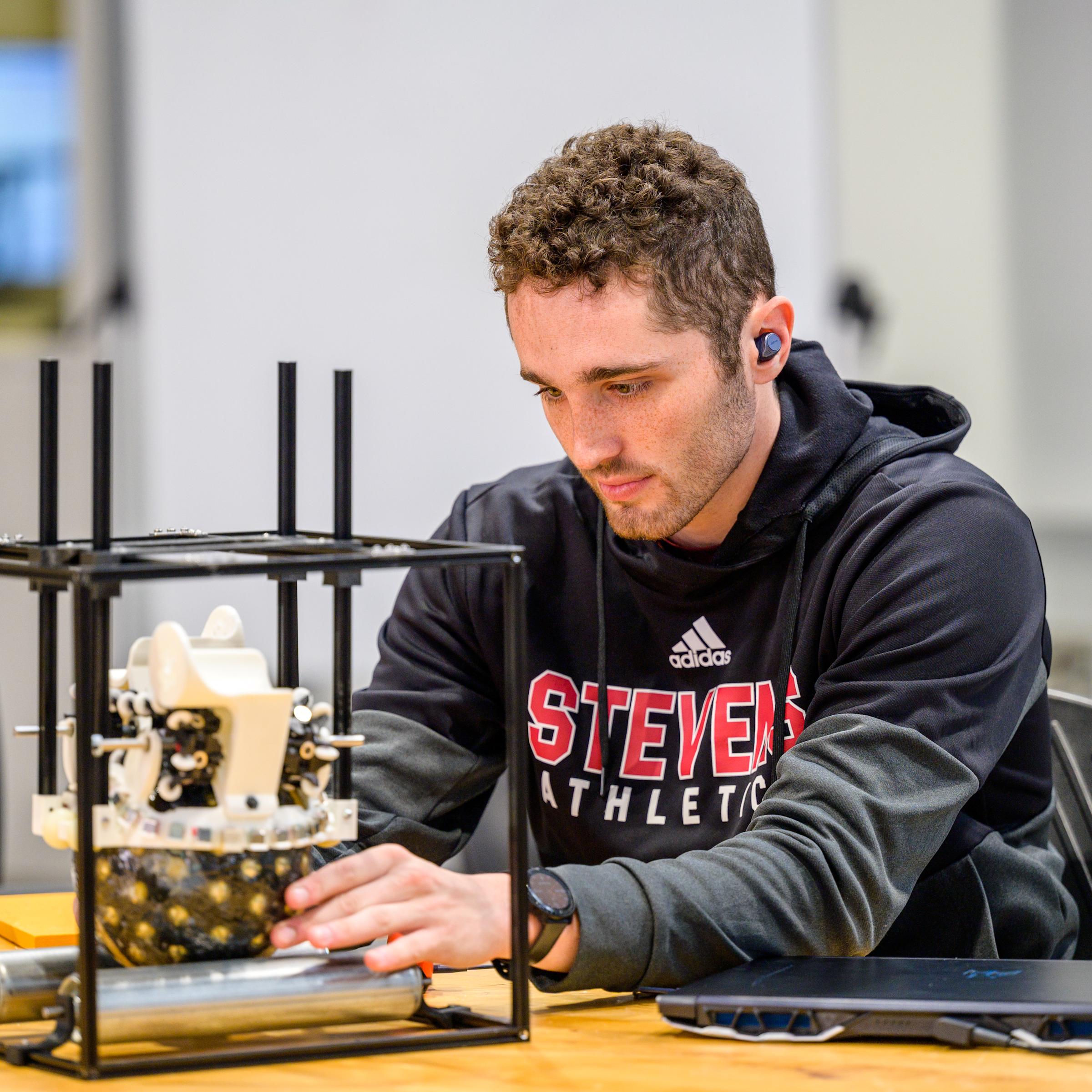 student wearing a black hoodie building his project