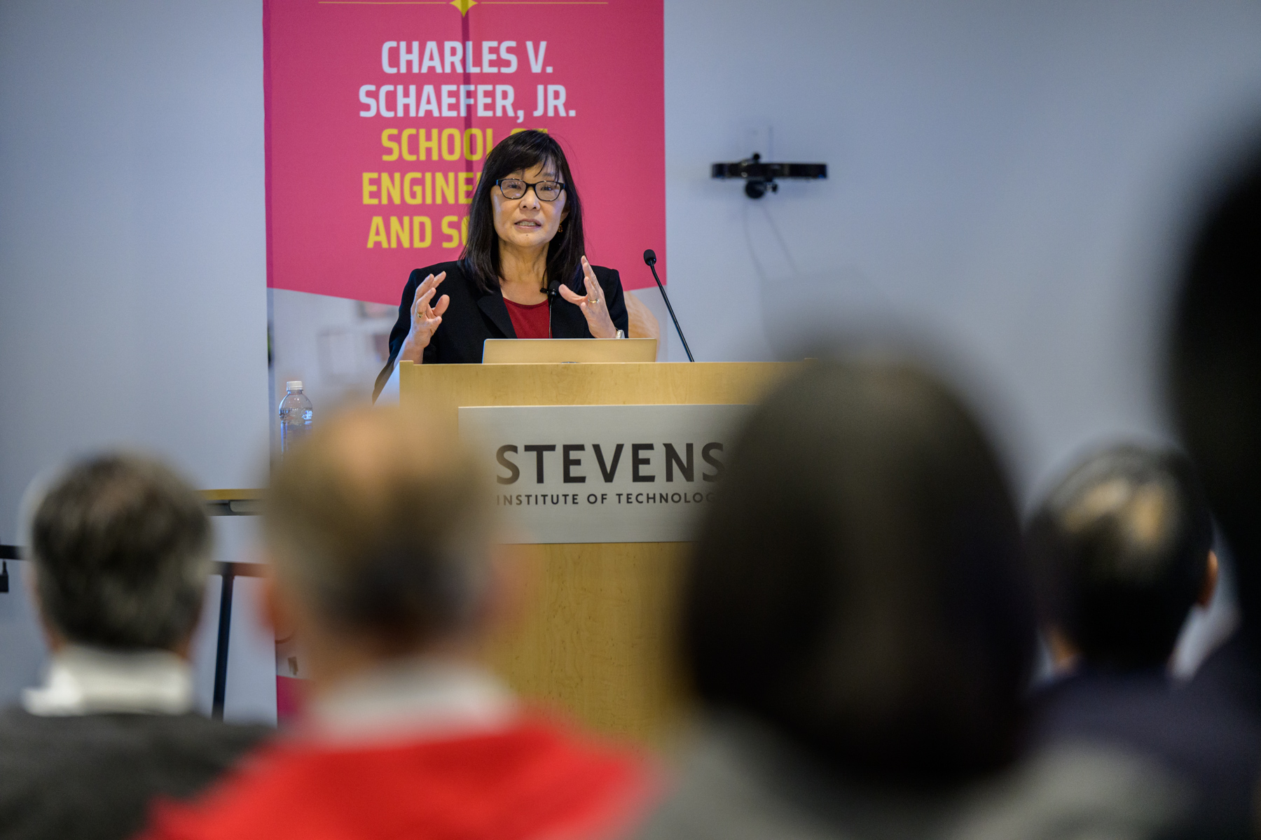 Rebecca Li speaking to audience members behind a podium.