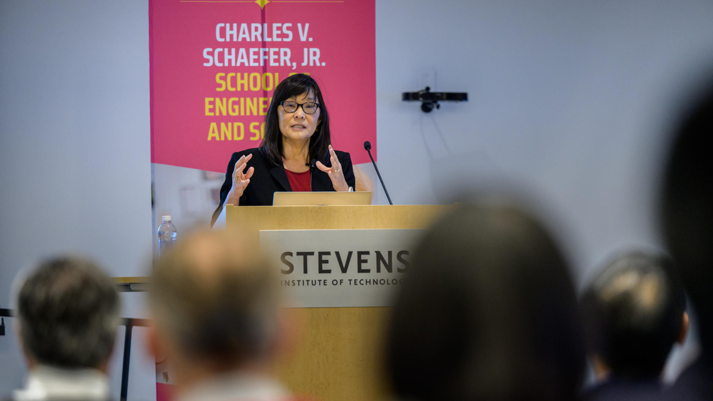 Rebecca Li speaking to audience members behind a podium.