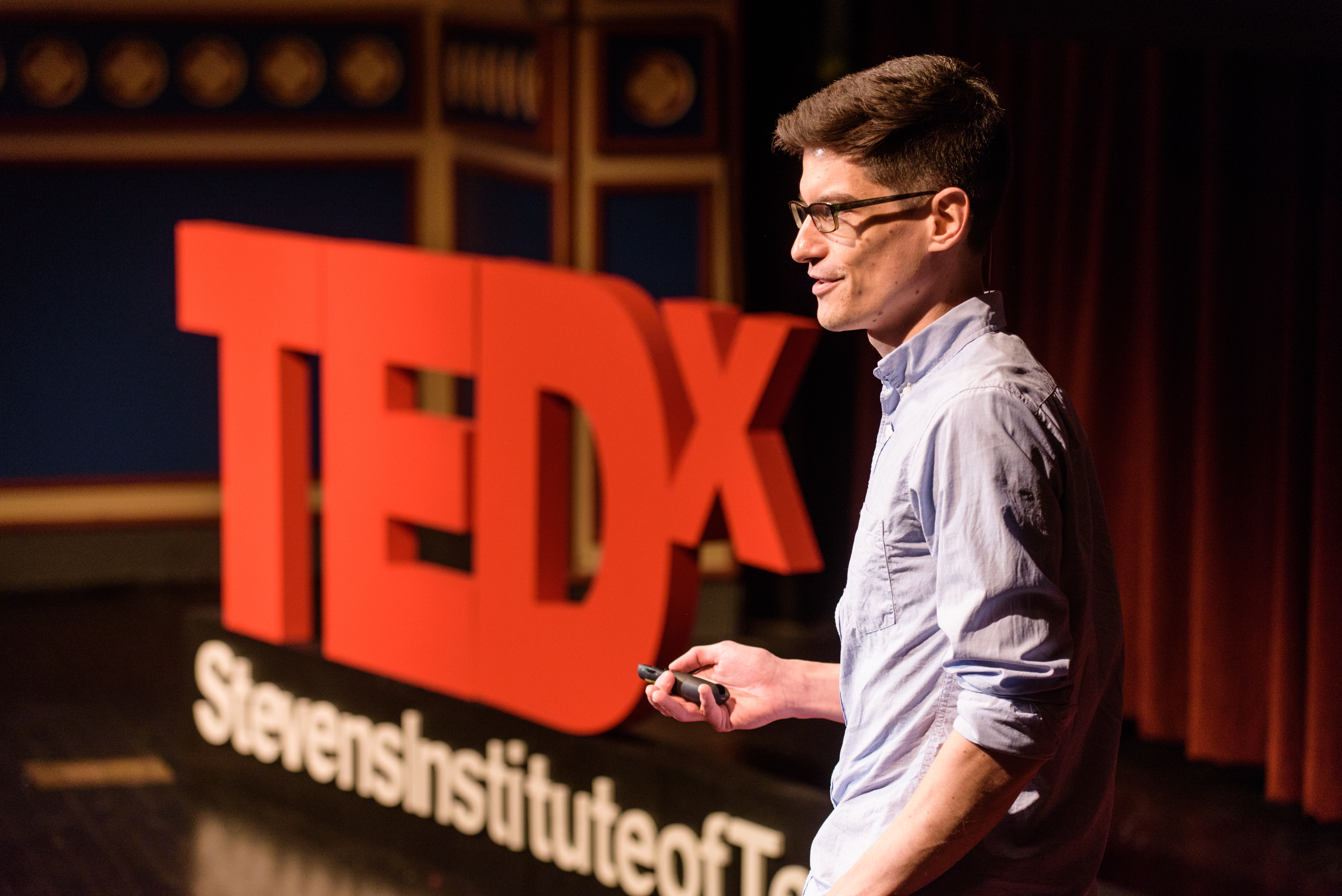 Jan Cannizzo on stage with a TEDx Talk display.