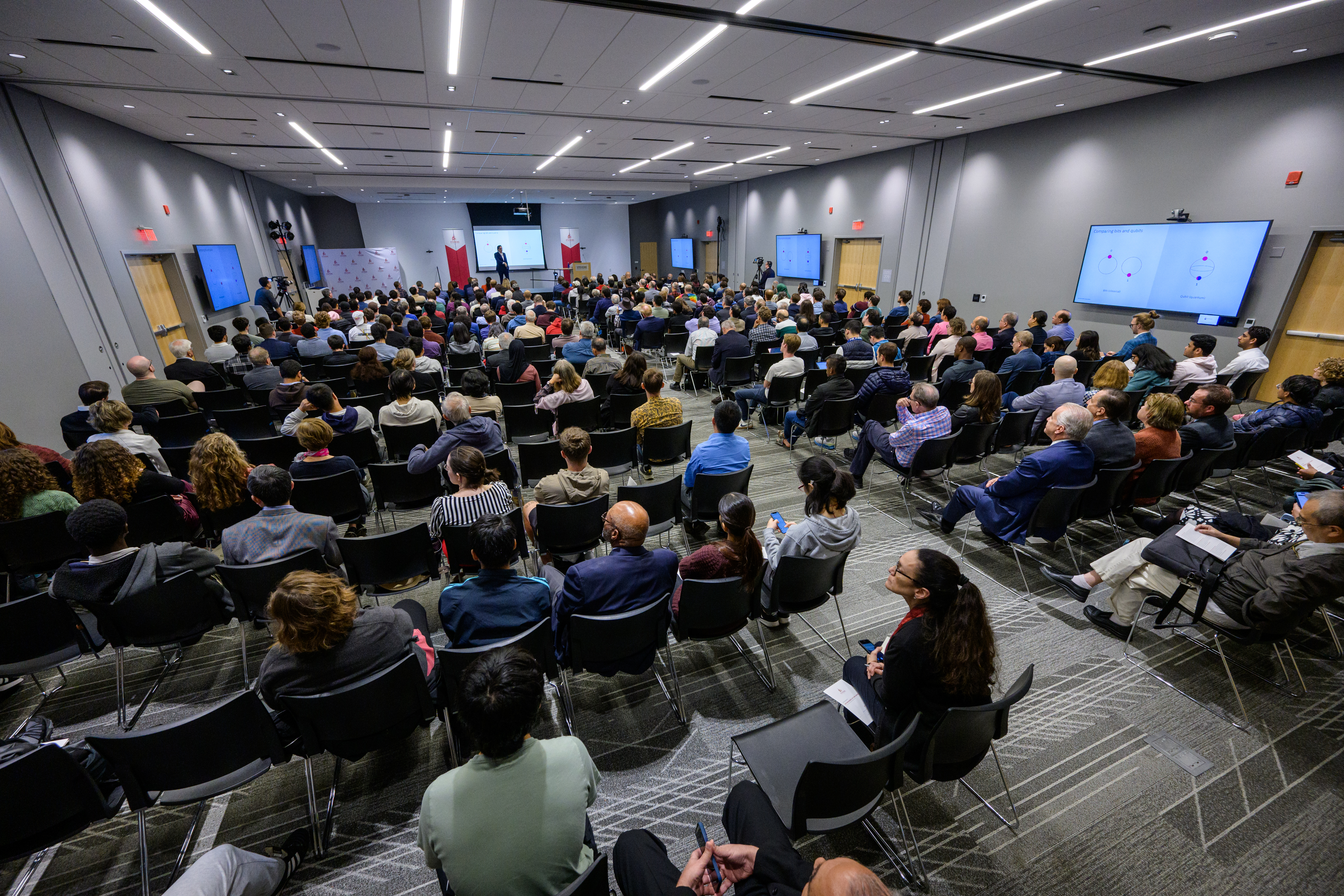 A wide shot of audience members seated during a seminar.