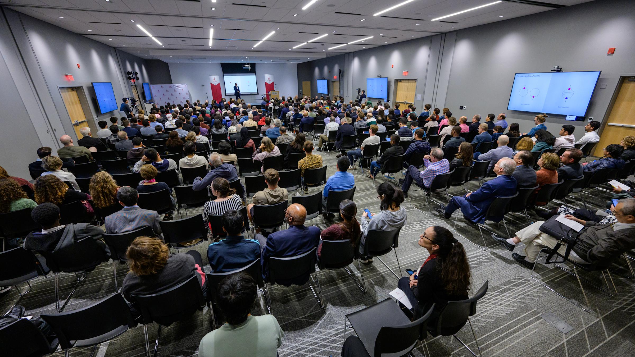 A wide shot of audience members seated during a seminar.