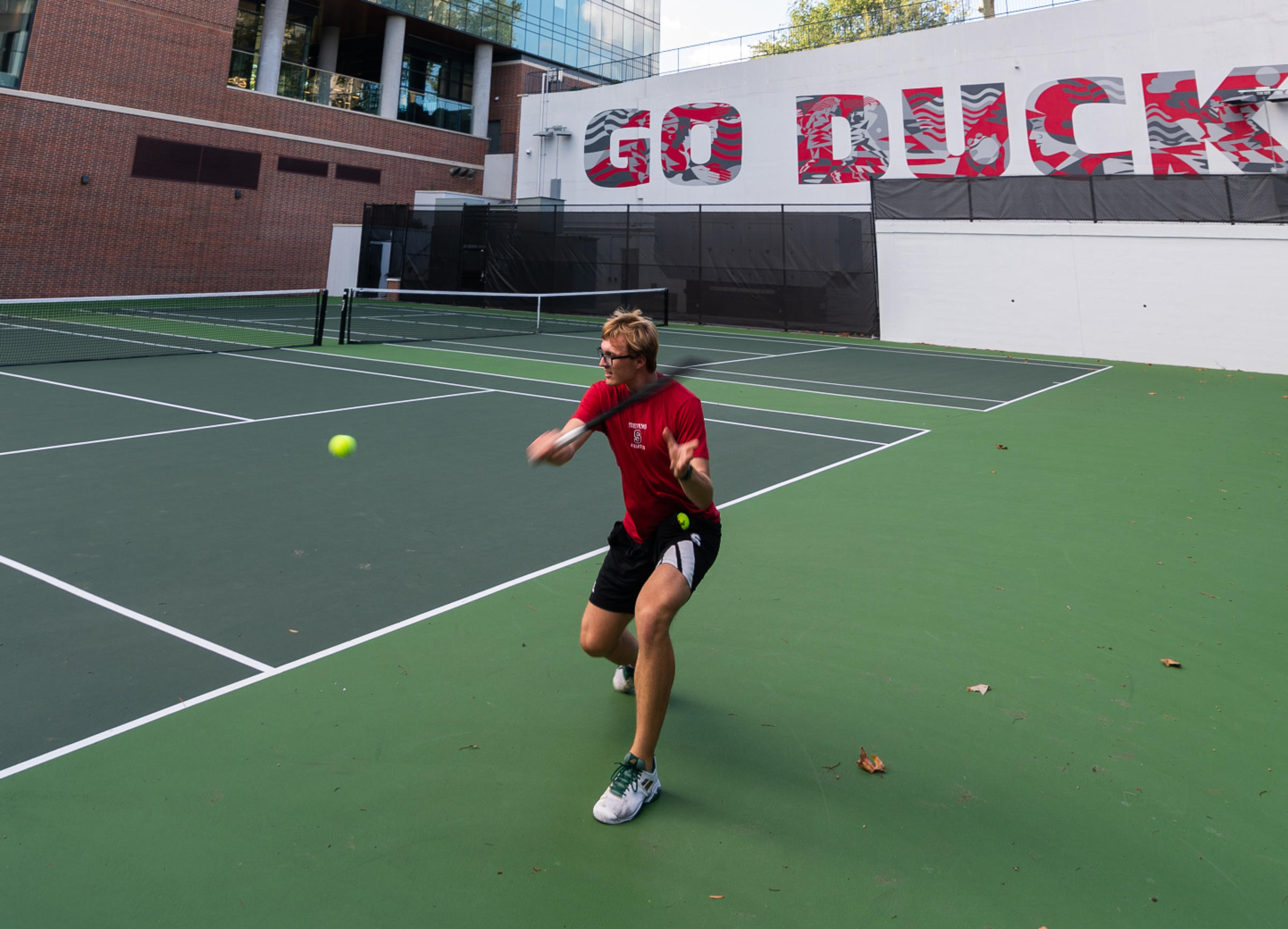 Tennis player about to hit tennis ball.