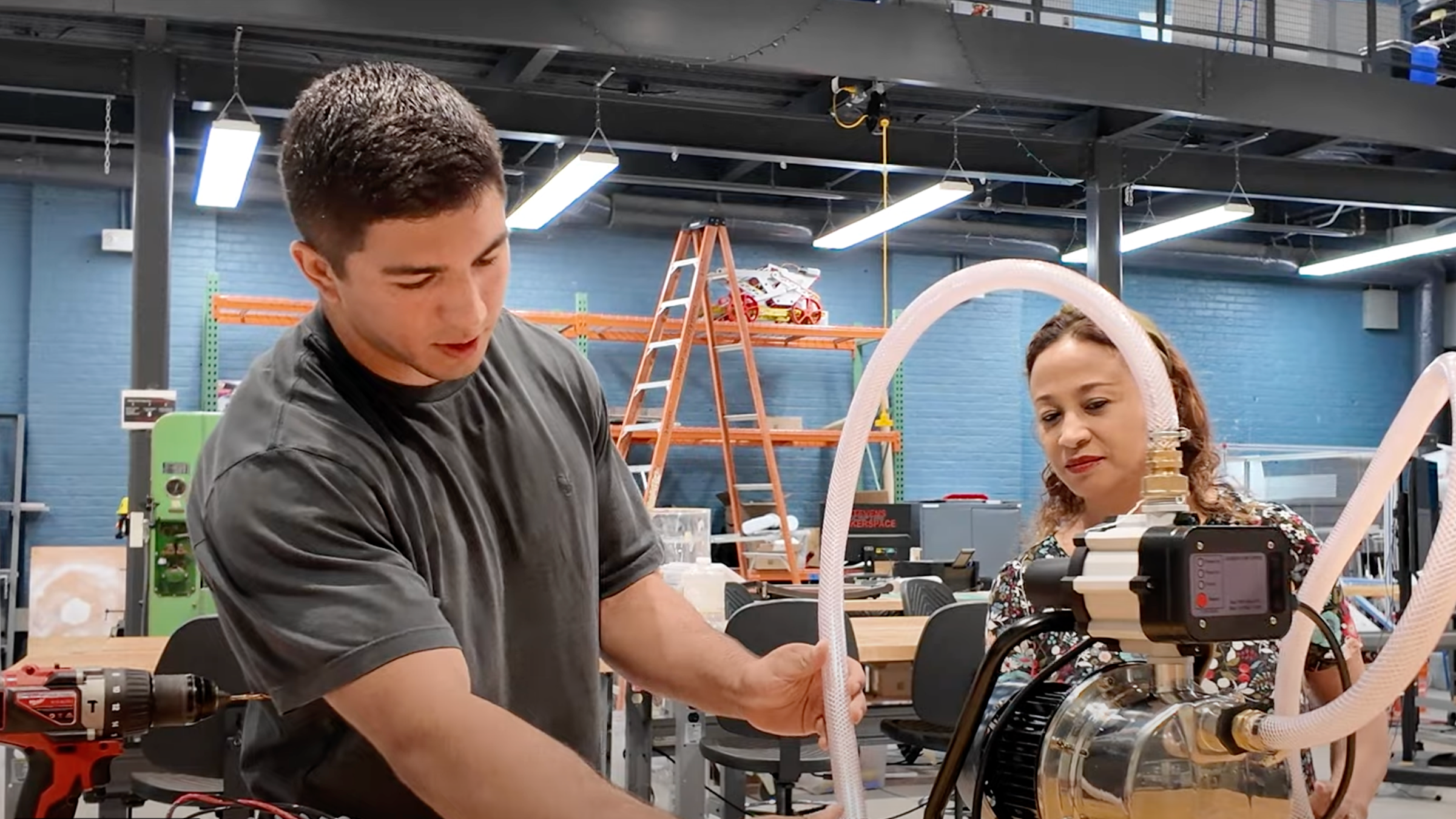 Student Harrison Hinojosa and Stevens Center for Sustainability Program Manager Rosita Nunez work on a water pressure project in the ABS Engineering Center.