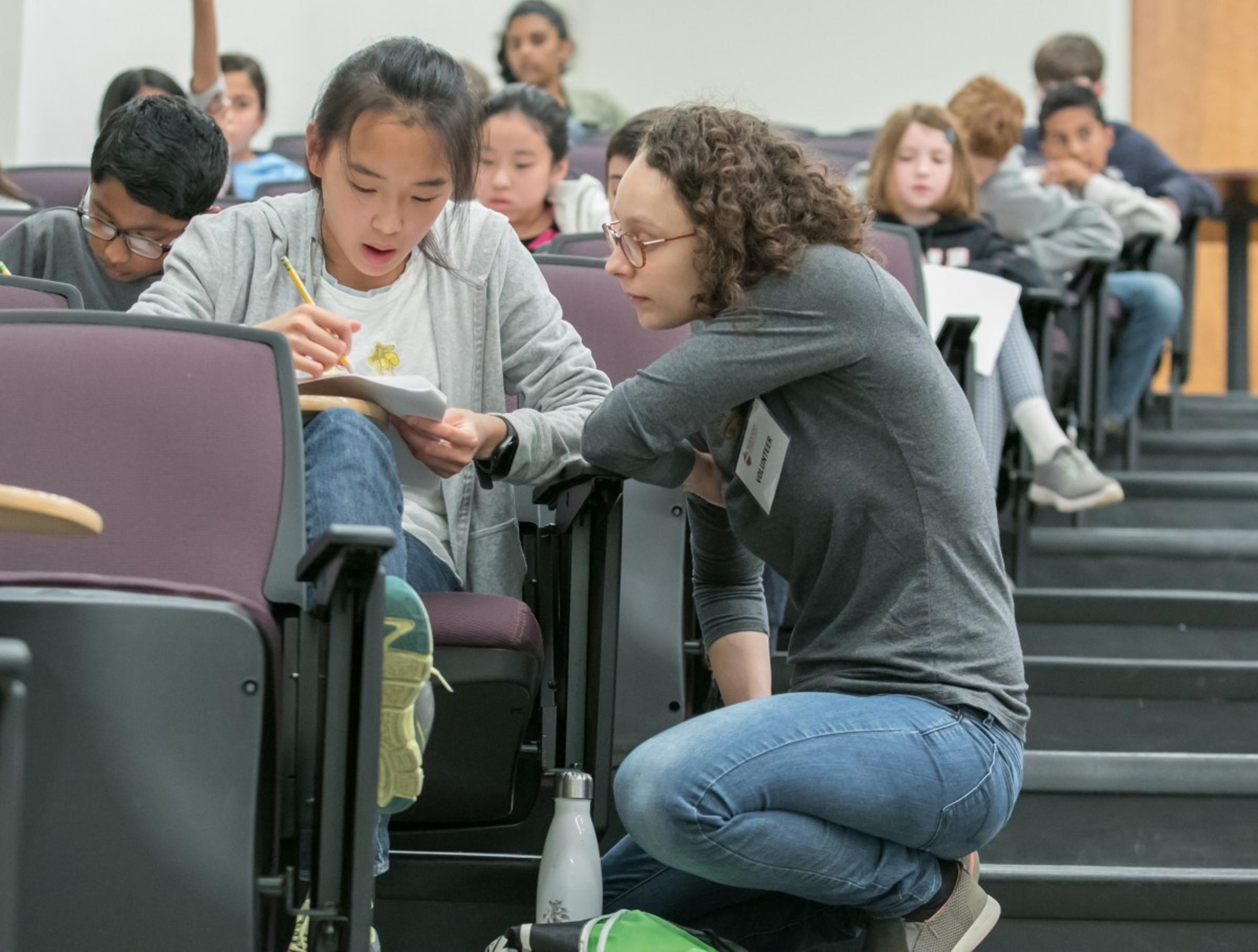 Volunteer helping student in classroom