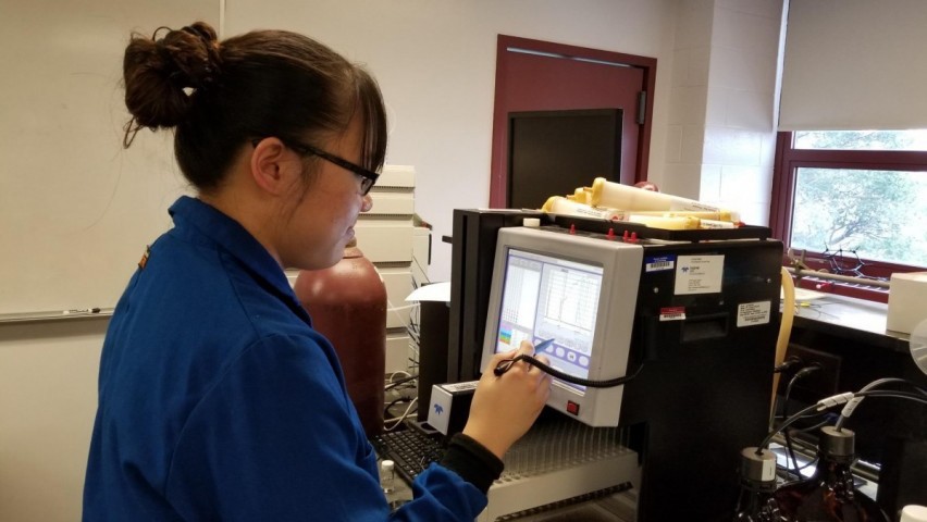 Graduate student Lucia Wang using a liquid chromatography instrument