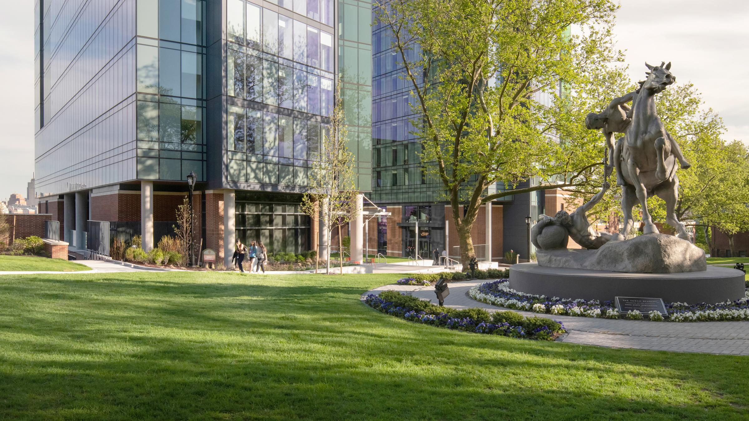 Torch Bearers sculpture on campus with UCC towers behond.