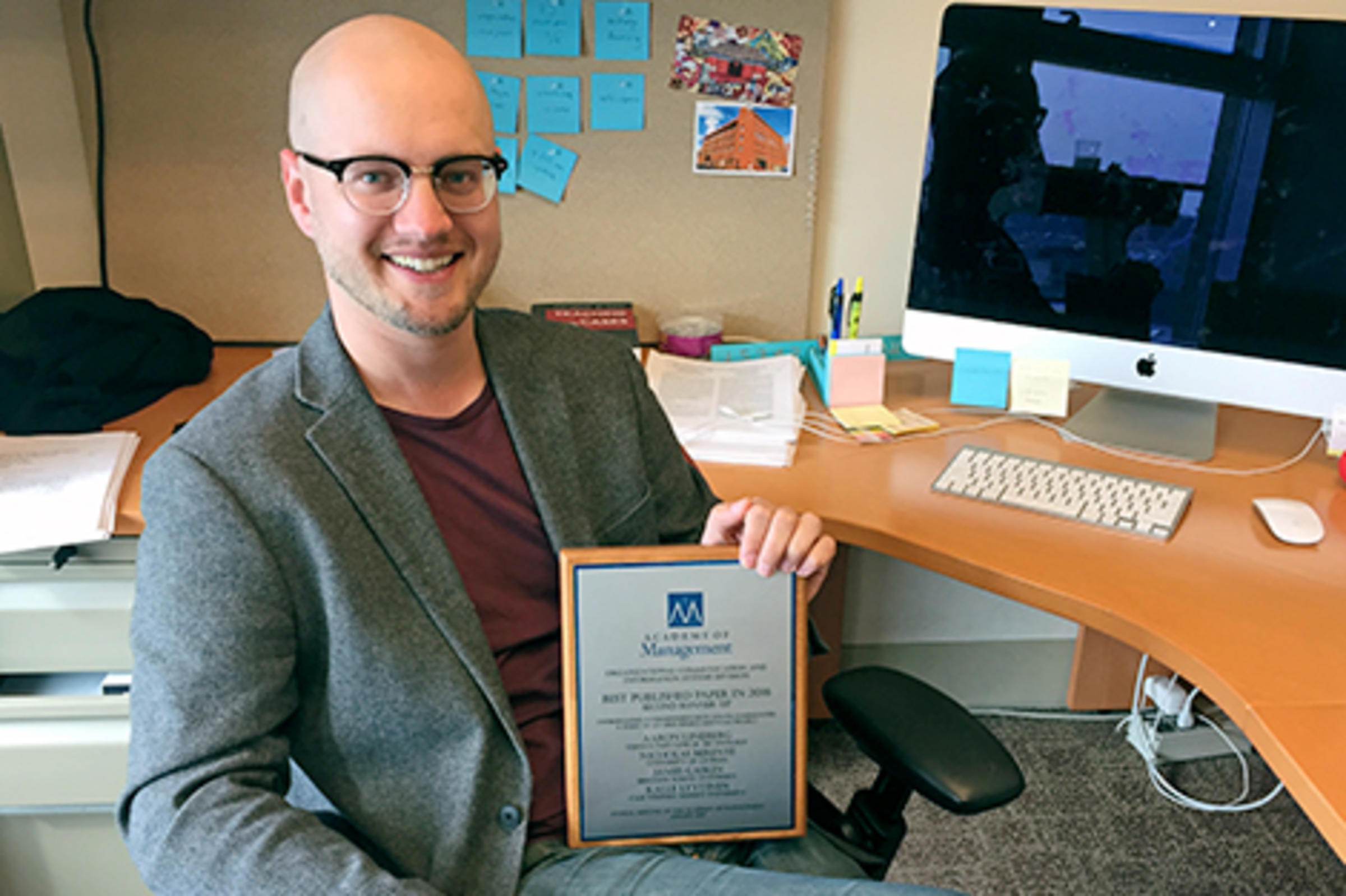 Aron Lindberg in his office at Stevens holding an award.