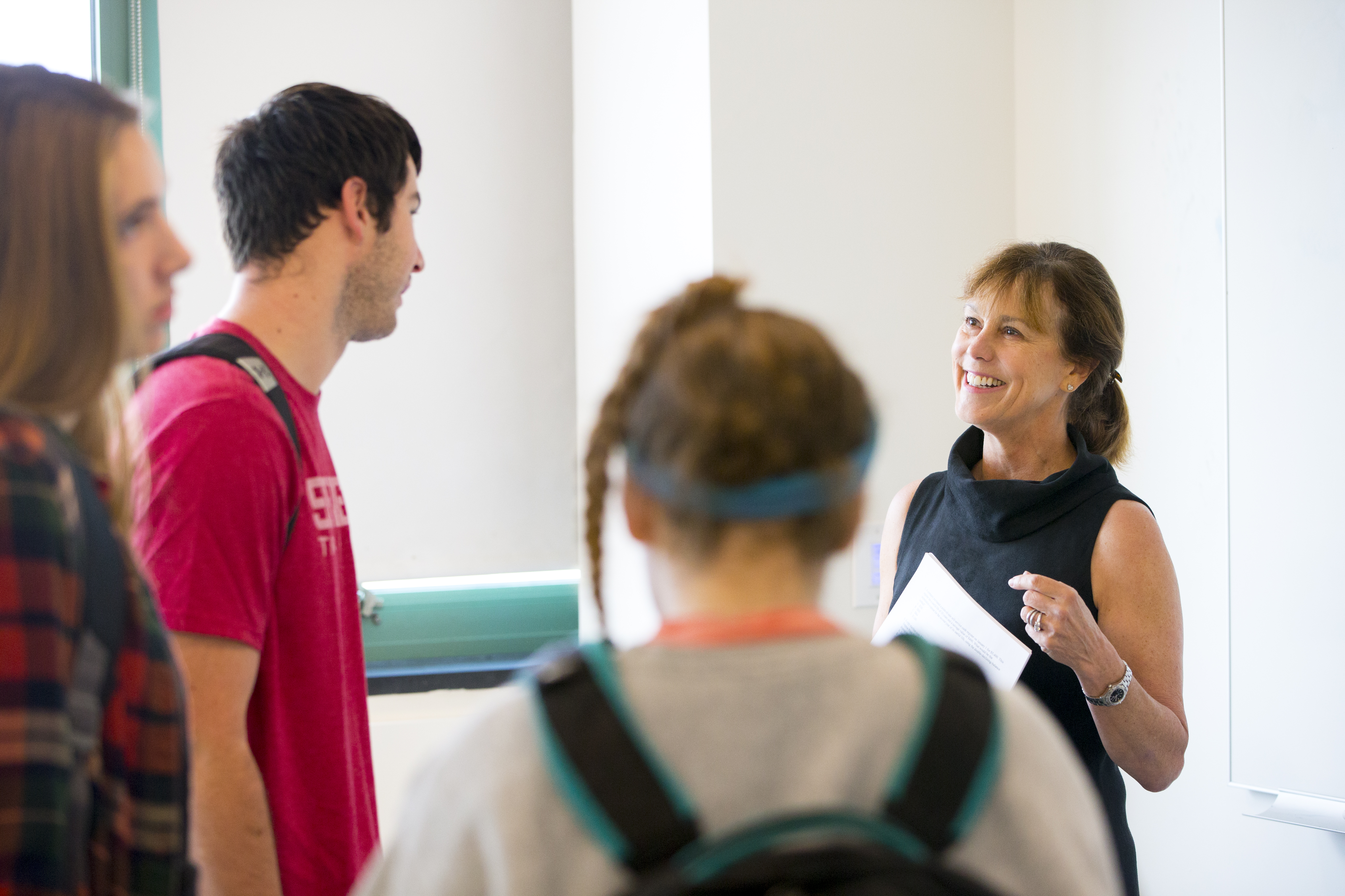 Professor teaches students an accounting concept on a white board 