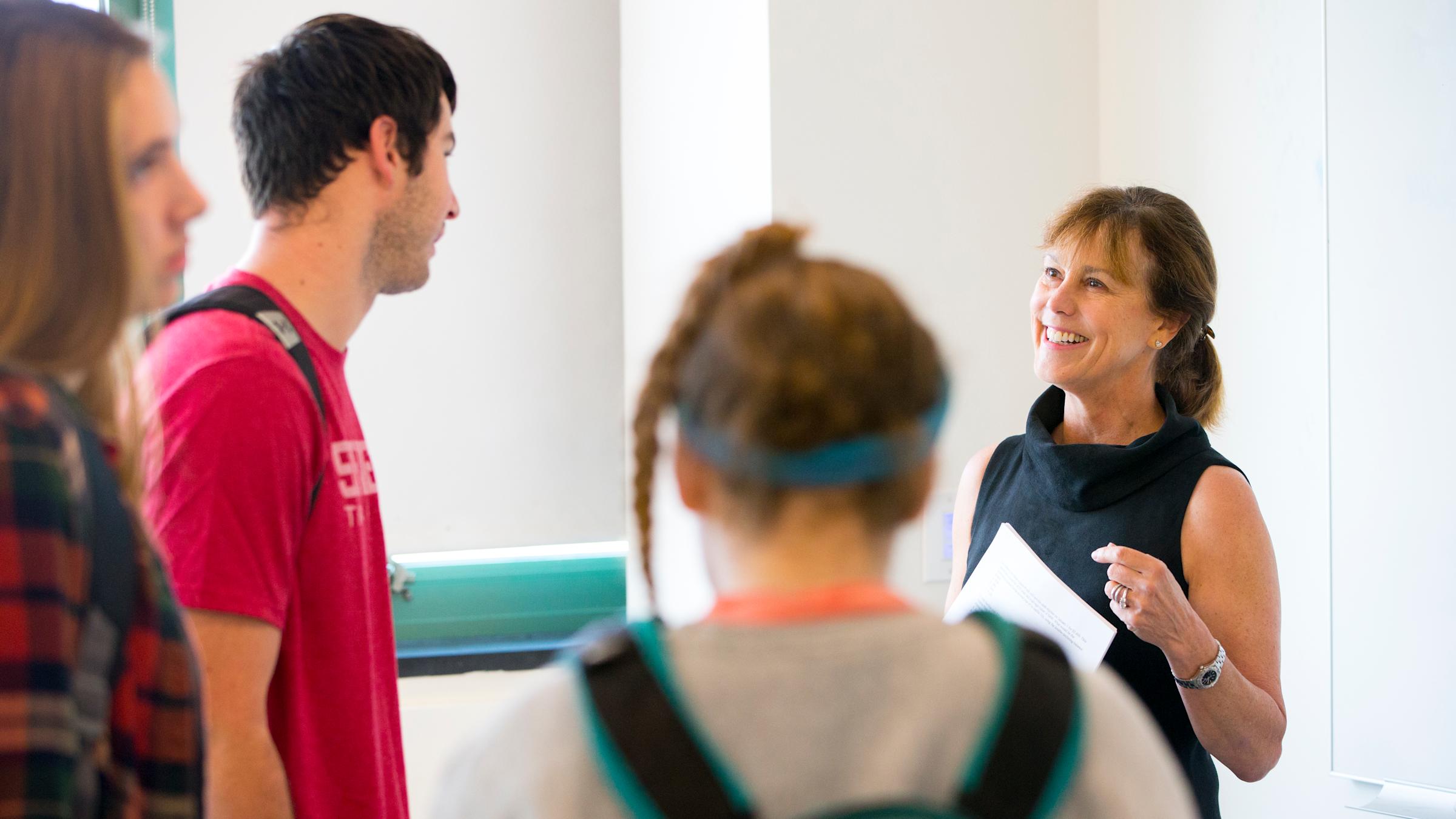 Professor teaches students an accounting concept on a white board