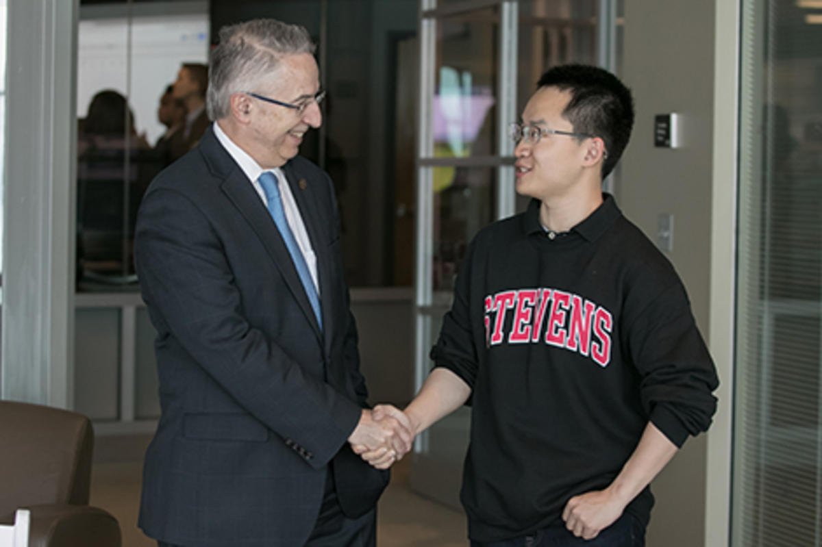 Gregory Prastacos shaking hands with Bruce Zhang at the Babbio Center at Stevens.